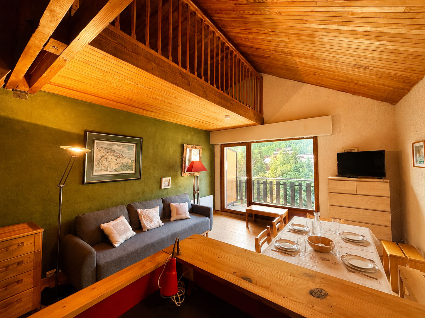 image Rich green walls set a warm tone in the living room, with a large window looking out over the resort.