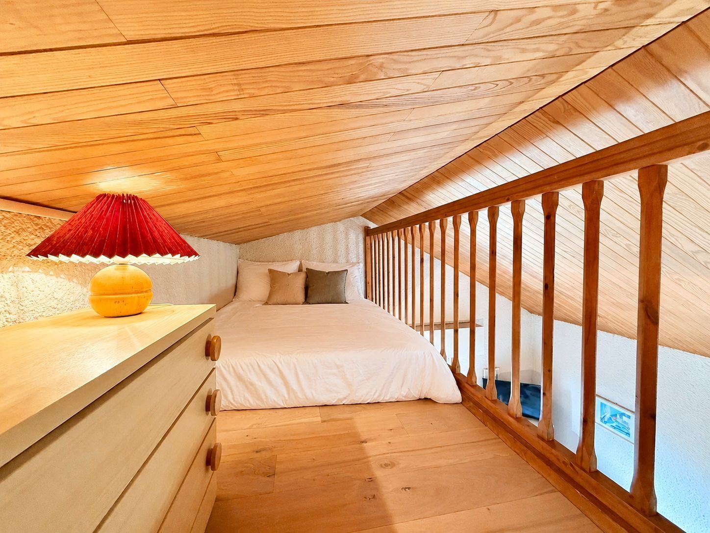 image The mezzanine bedroom offers a cosy double bed beneath warm bedside lighting.
