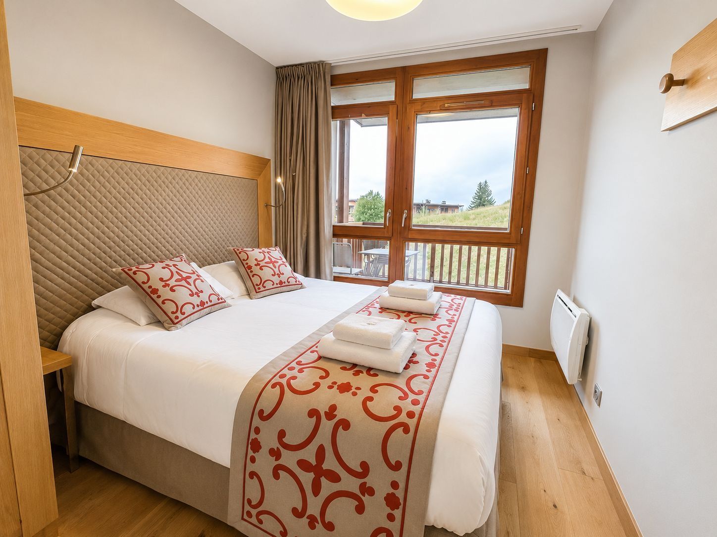 image Twin beds dressed in red alpine-patterned throws, wood-paneled walls