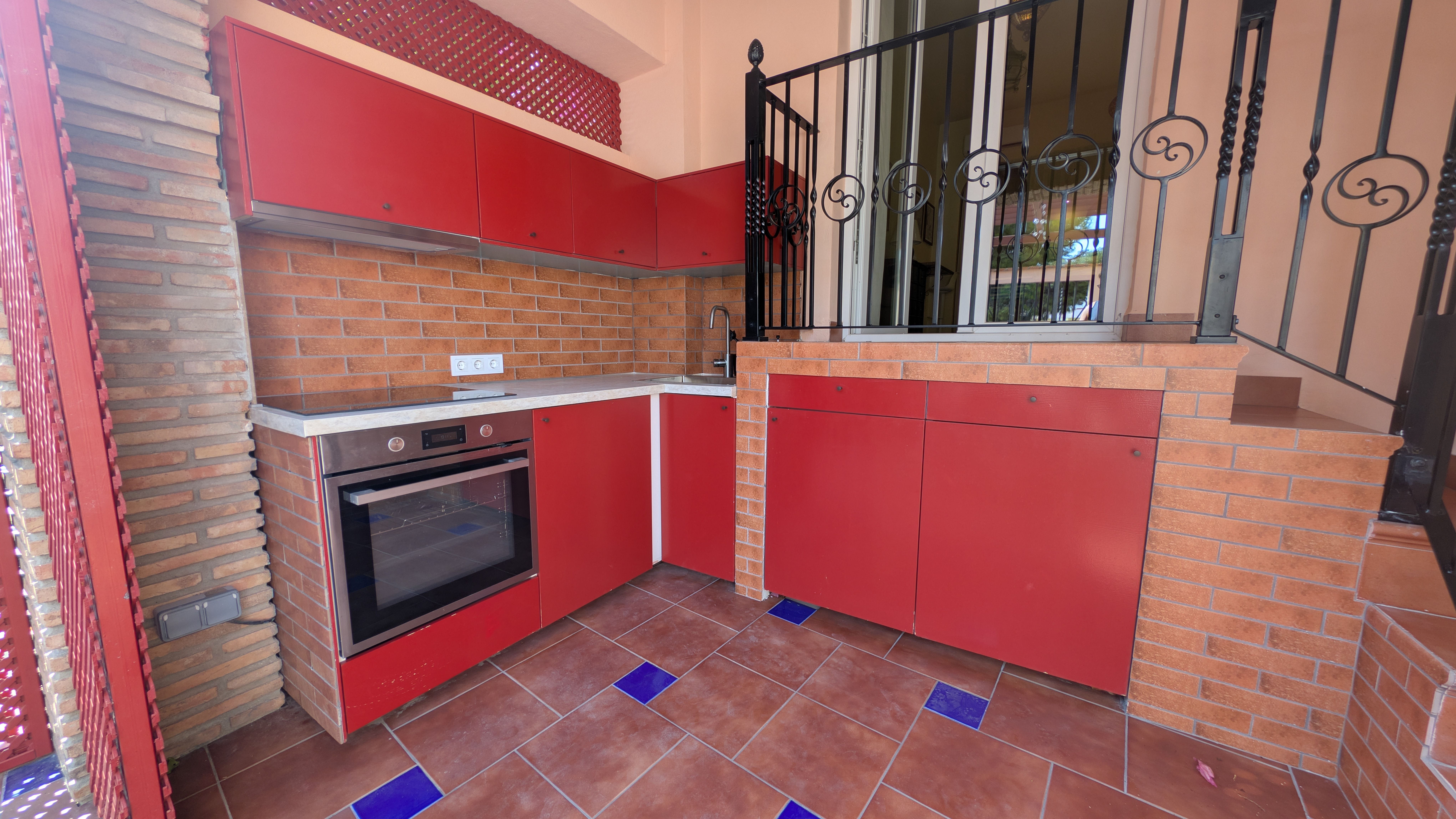 image Private terrace featuring a fully equipped outdoor kitchen with an oven, induction hob, fridge, and washing machine.