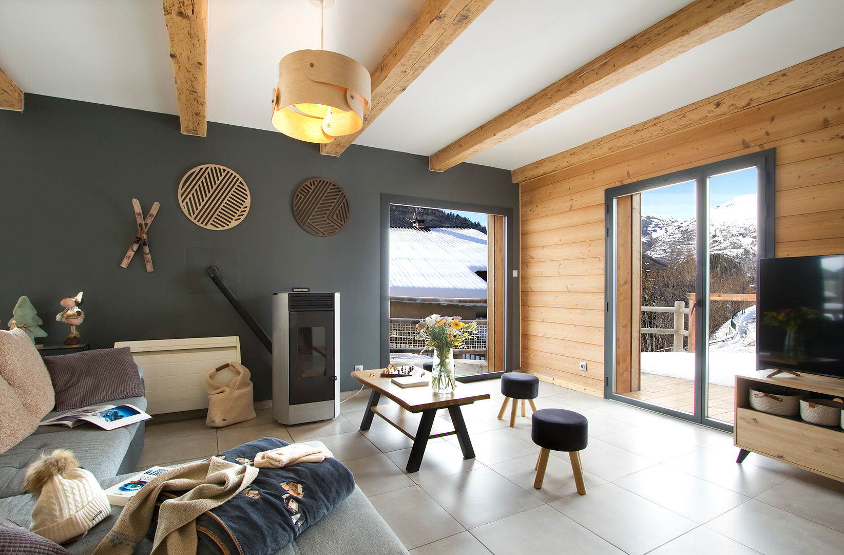 image Living room with wood-burning stove, dark accent wall, and mountain view