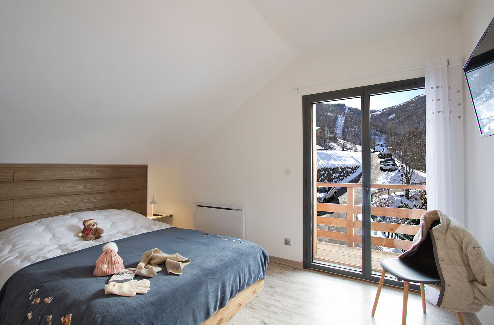 image Bedroom with double bed, sliding doors leading to a snowy balcony