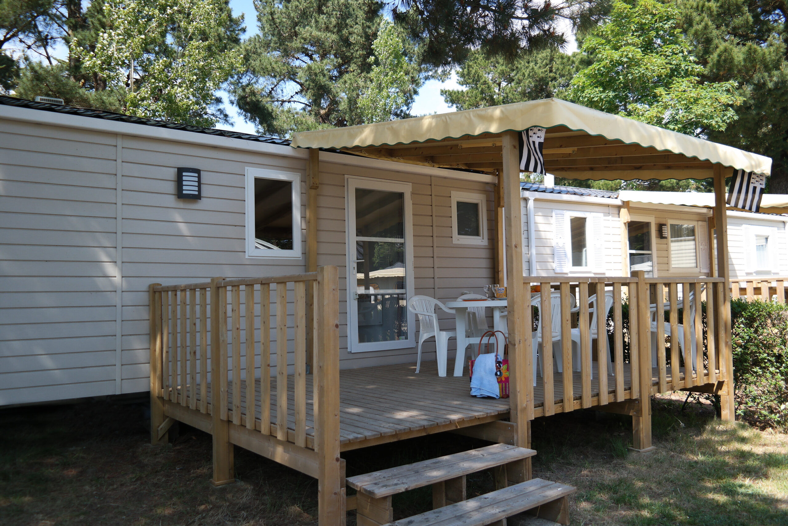 image The exterior of the mobile home, with its shaded deck and steps.