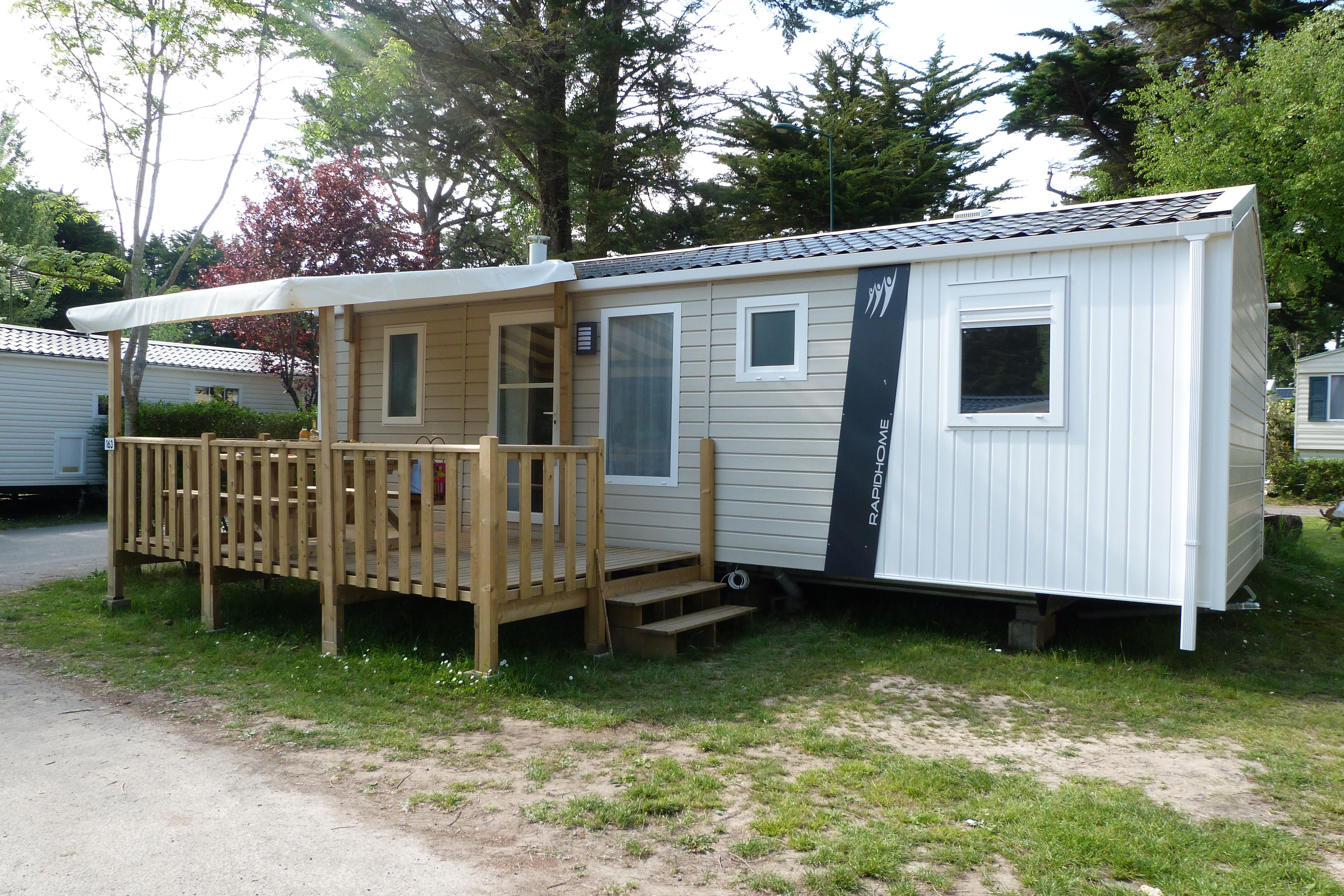image The exterior of the mobile home, with its wooden deck and terrace.