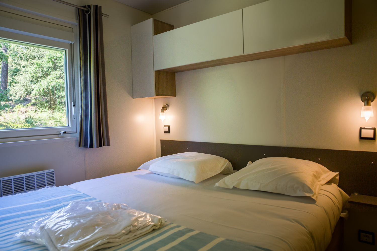 image The double bedroom, with bedside lighting and a garden view.