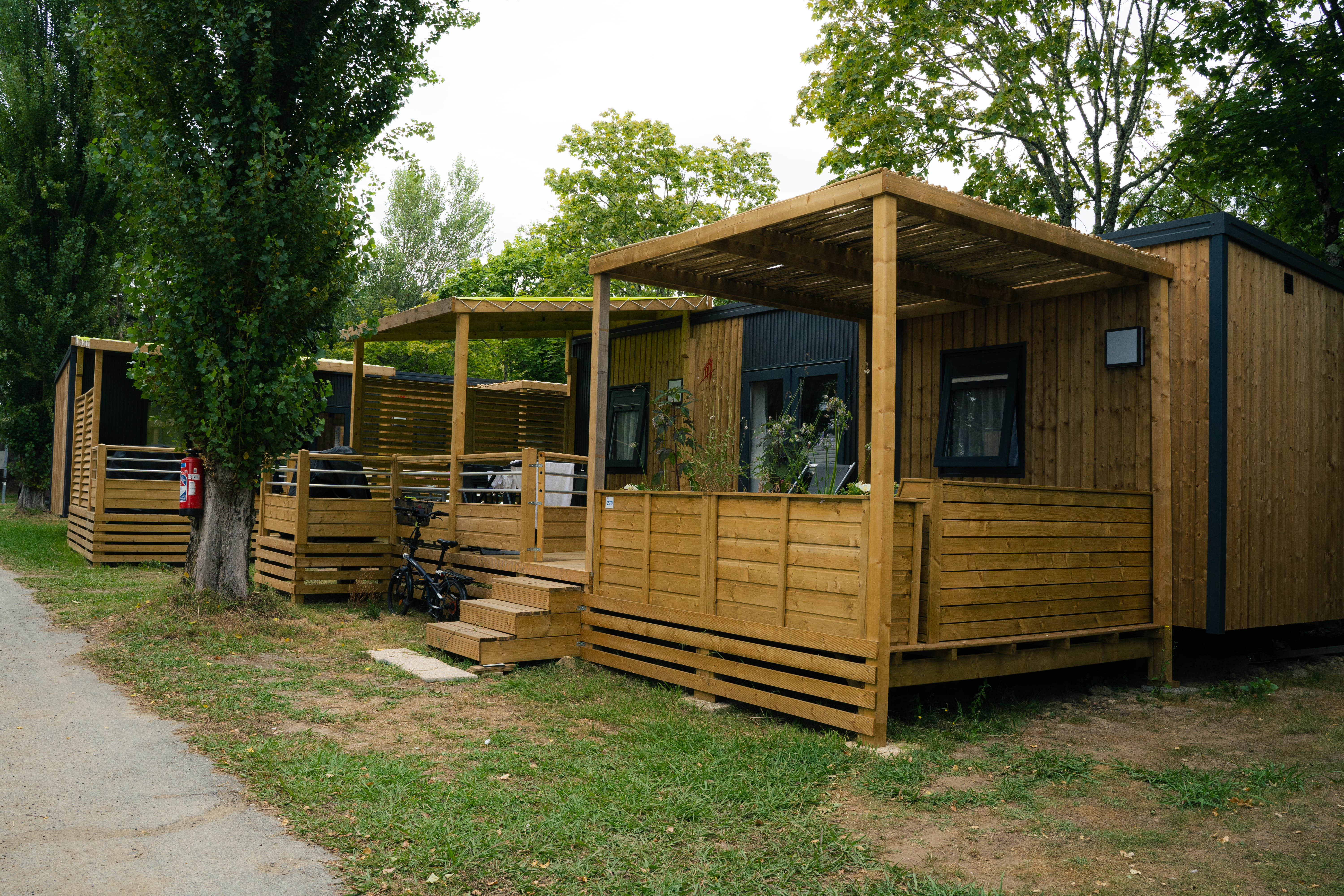 image The mobile homes set among trees, with their wooden terraces.