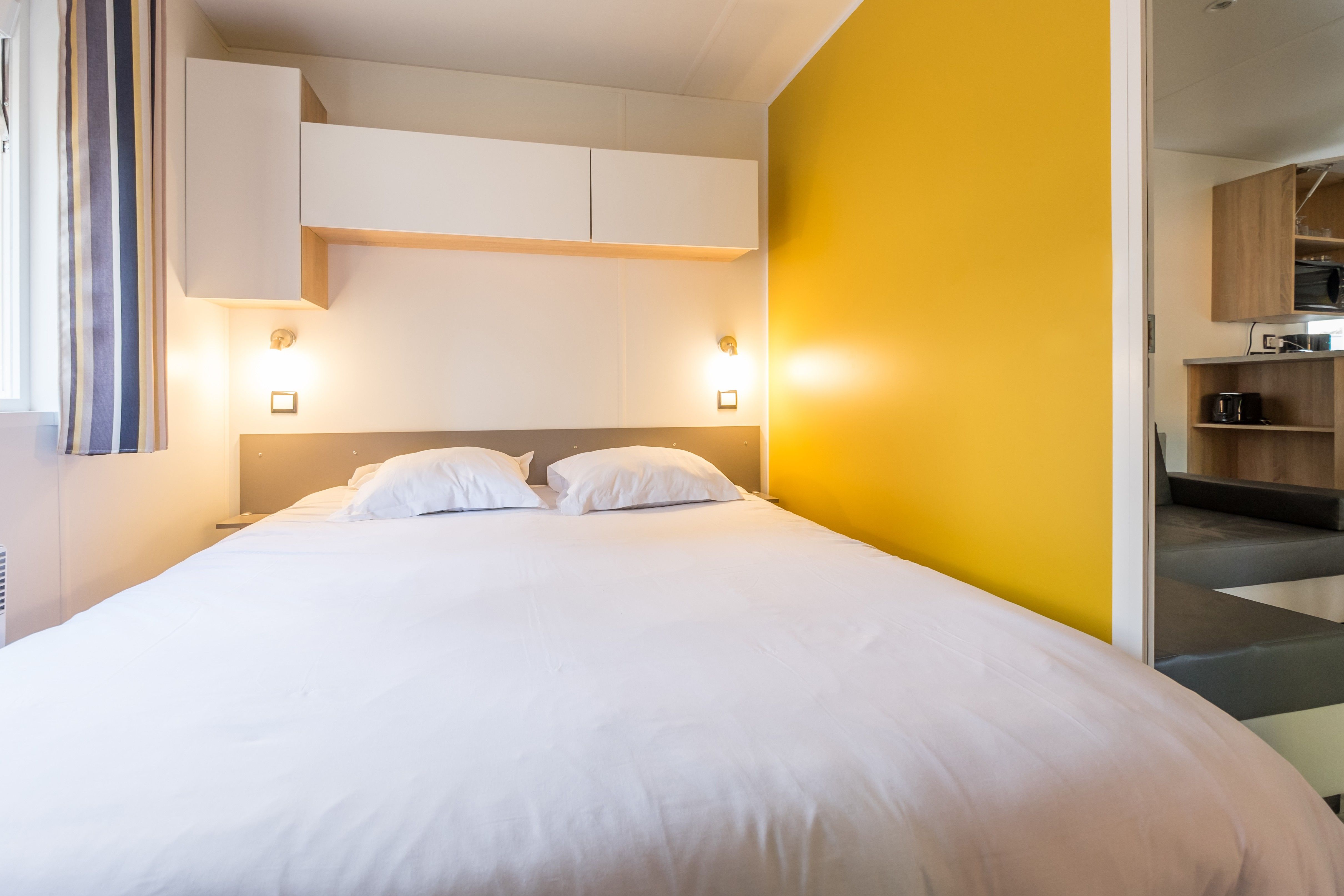 image The double bedroom, with a bright accent wall and reading lights.
