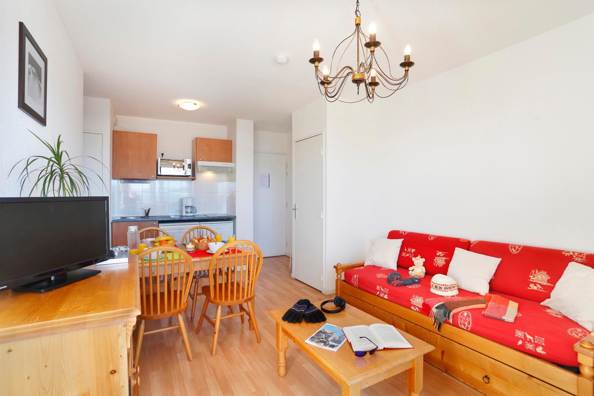 image Open-plan living room with fitted kitchenette, hob, microwave and dishwasher