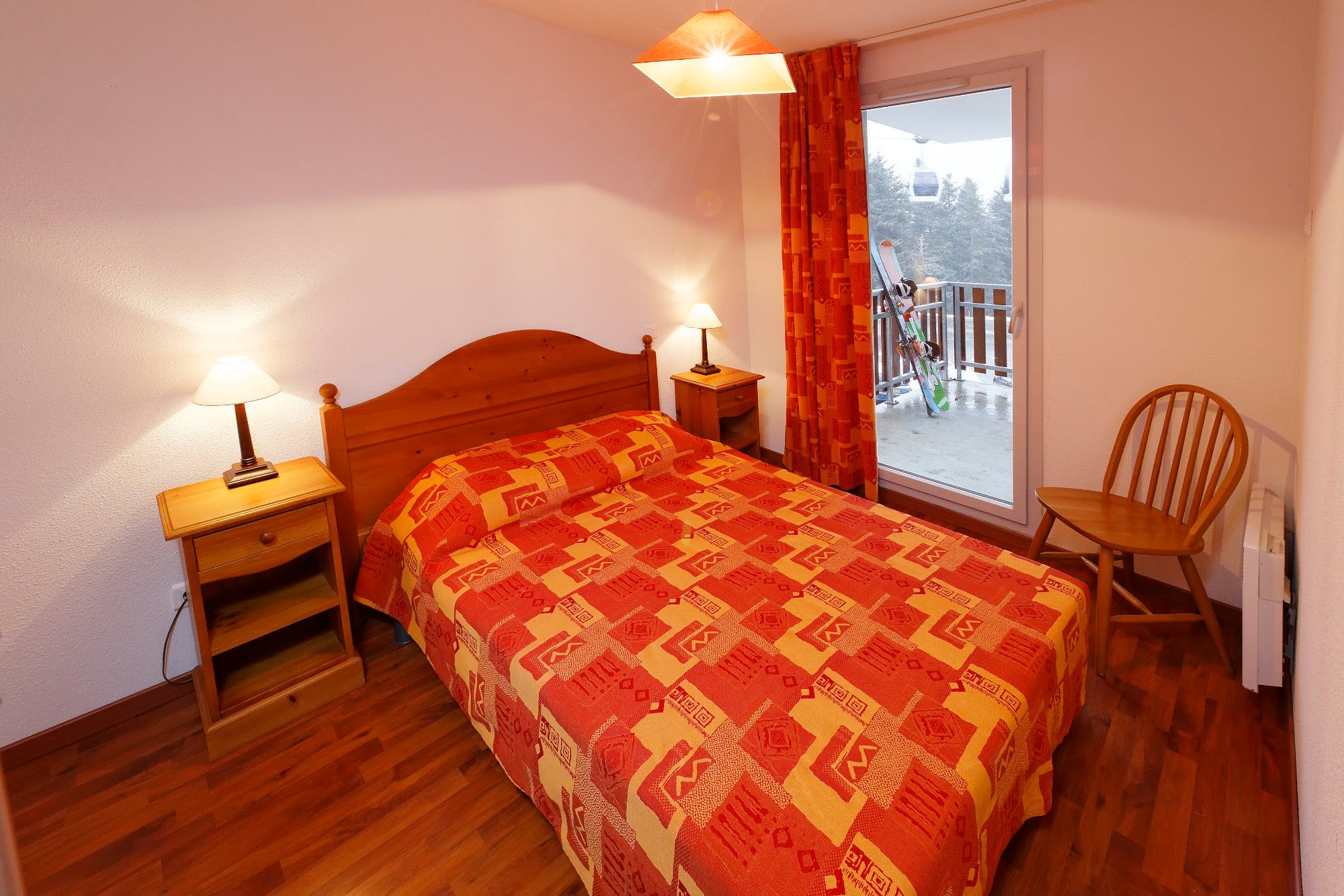 image Cozy bedroom with balcony access, perfect for post-ski relaxation.