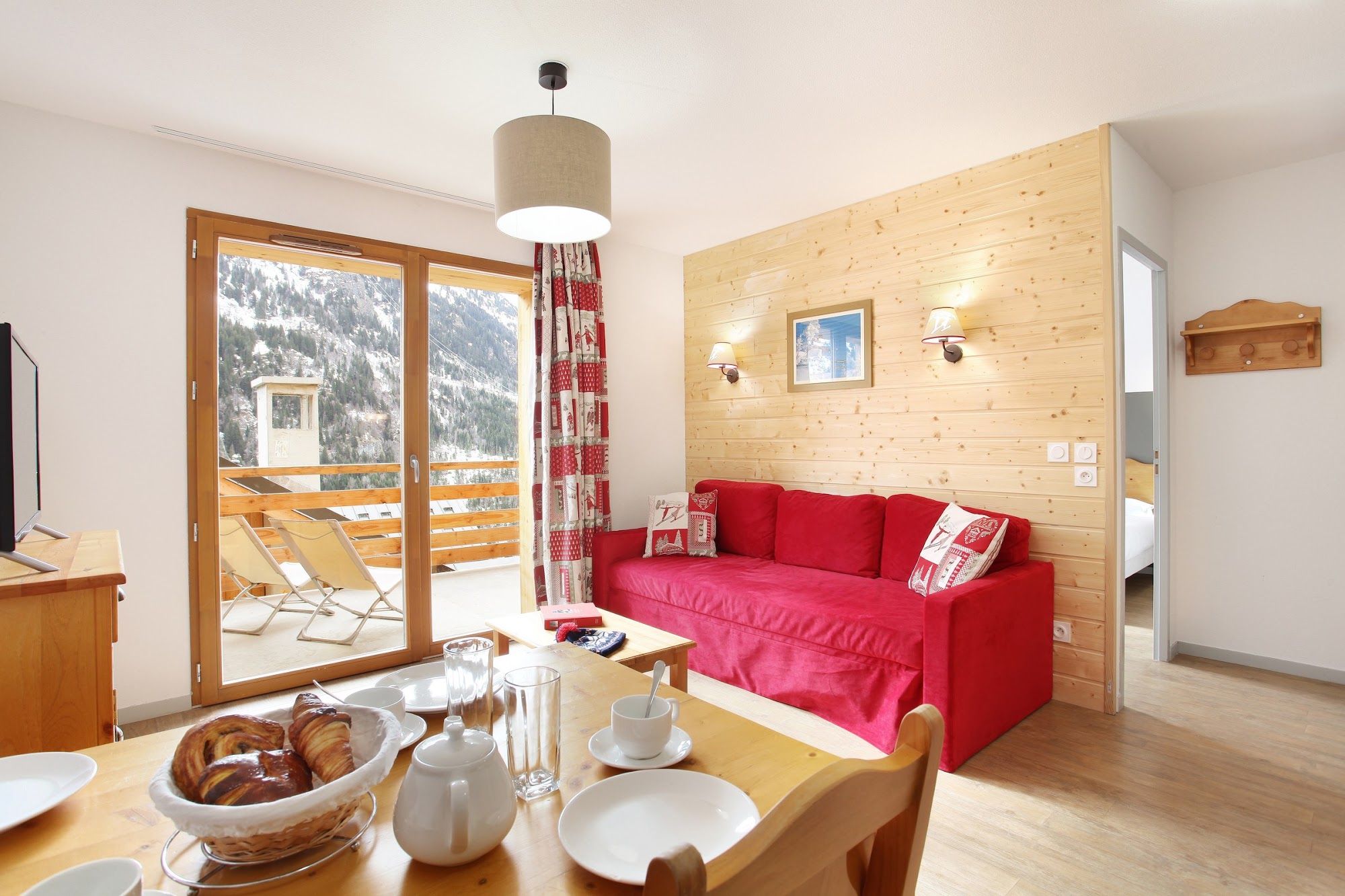 image Red sofa and dining table beside a glazed door