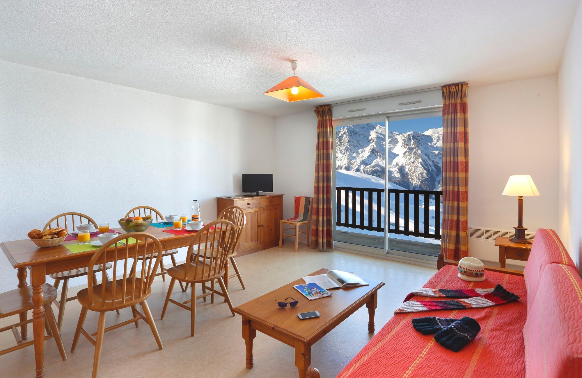 image Living and dining area looking towards the balcony and the mountains beyond