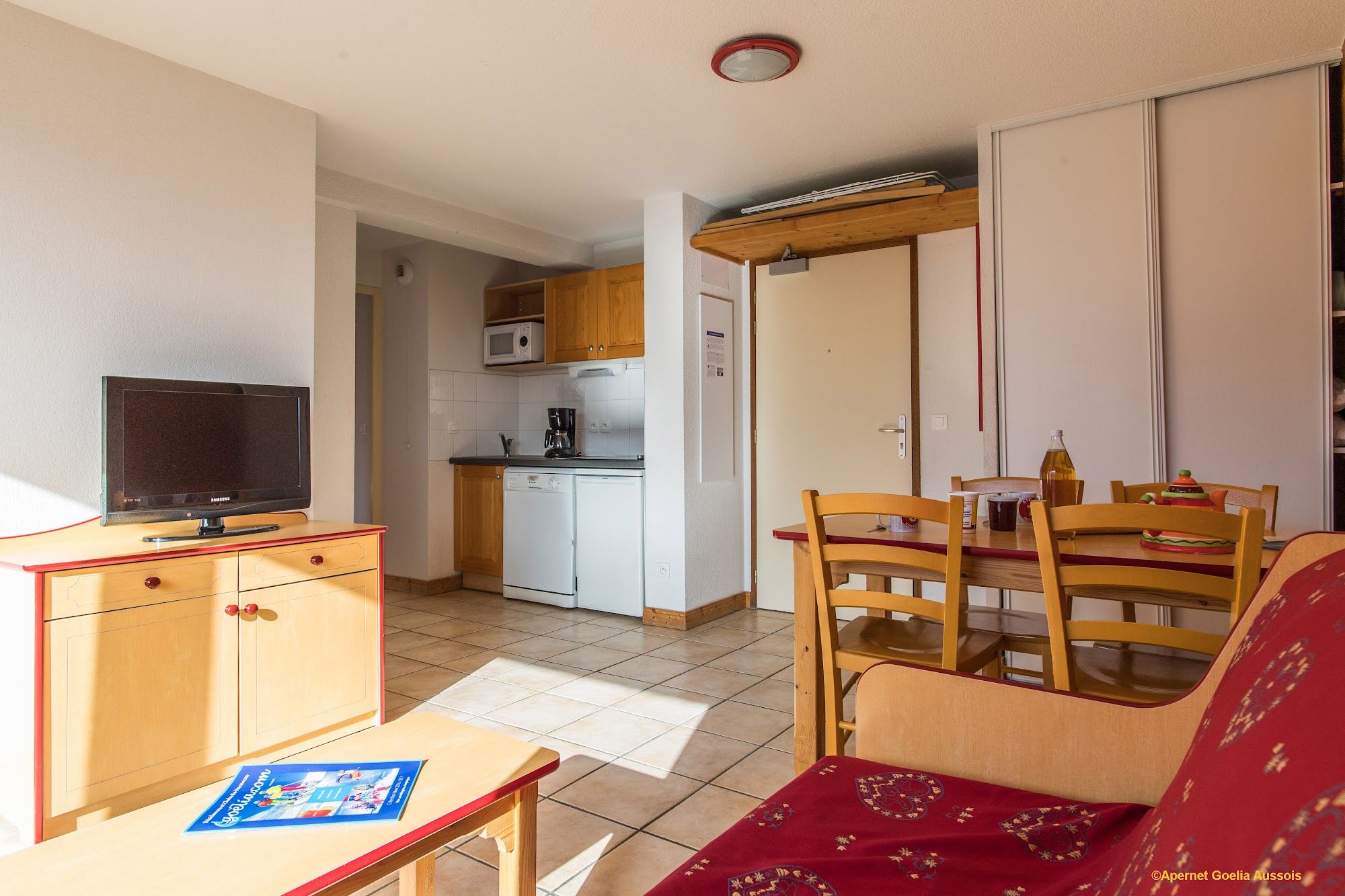 image Living and dining space with flat-screen TV, kitchenette and sofa bed