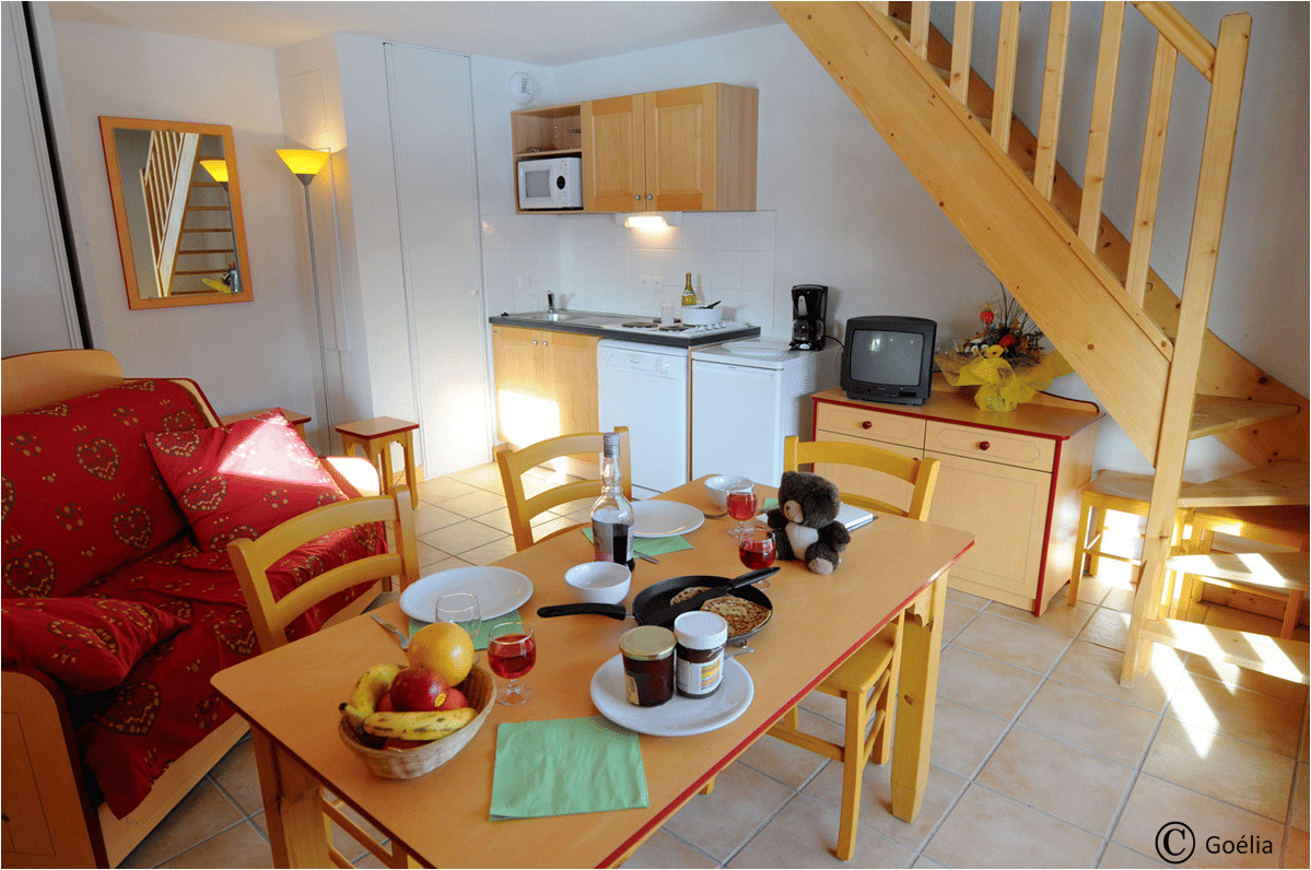image Open-plan living and dining area with sofa bed, kitchenette and stairs to an upper level