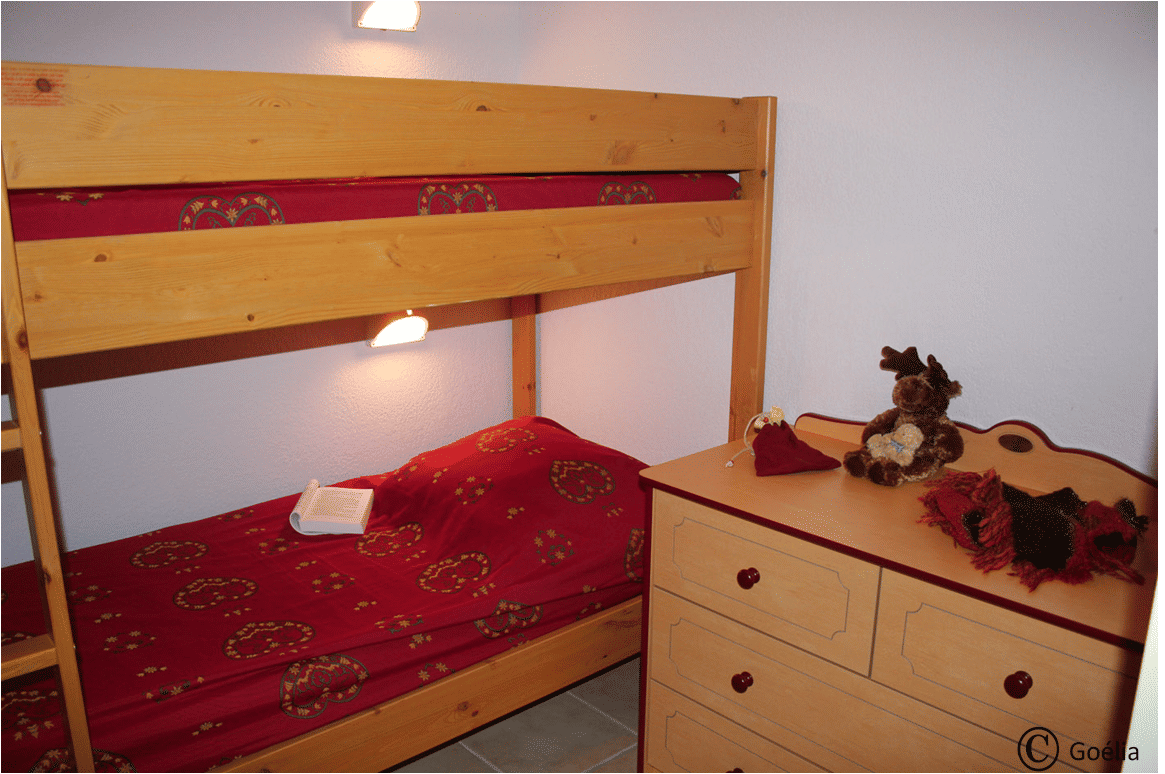 image Small room with bunk beds and a chest of drawers