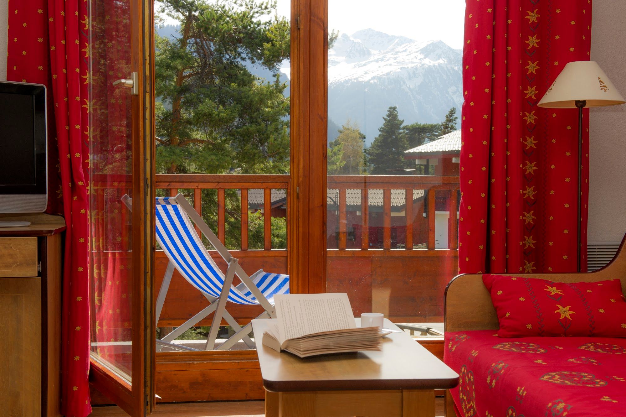 image Living area looking out through balcony doors to mountain peaks.