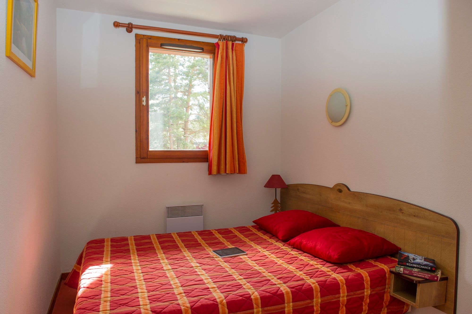 image Bedroom with a double bed, timber headboard and a panel heater.