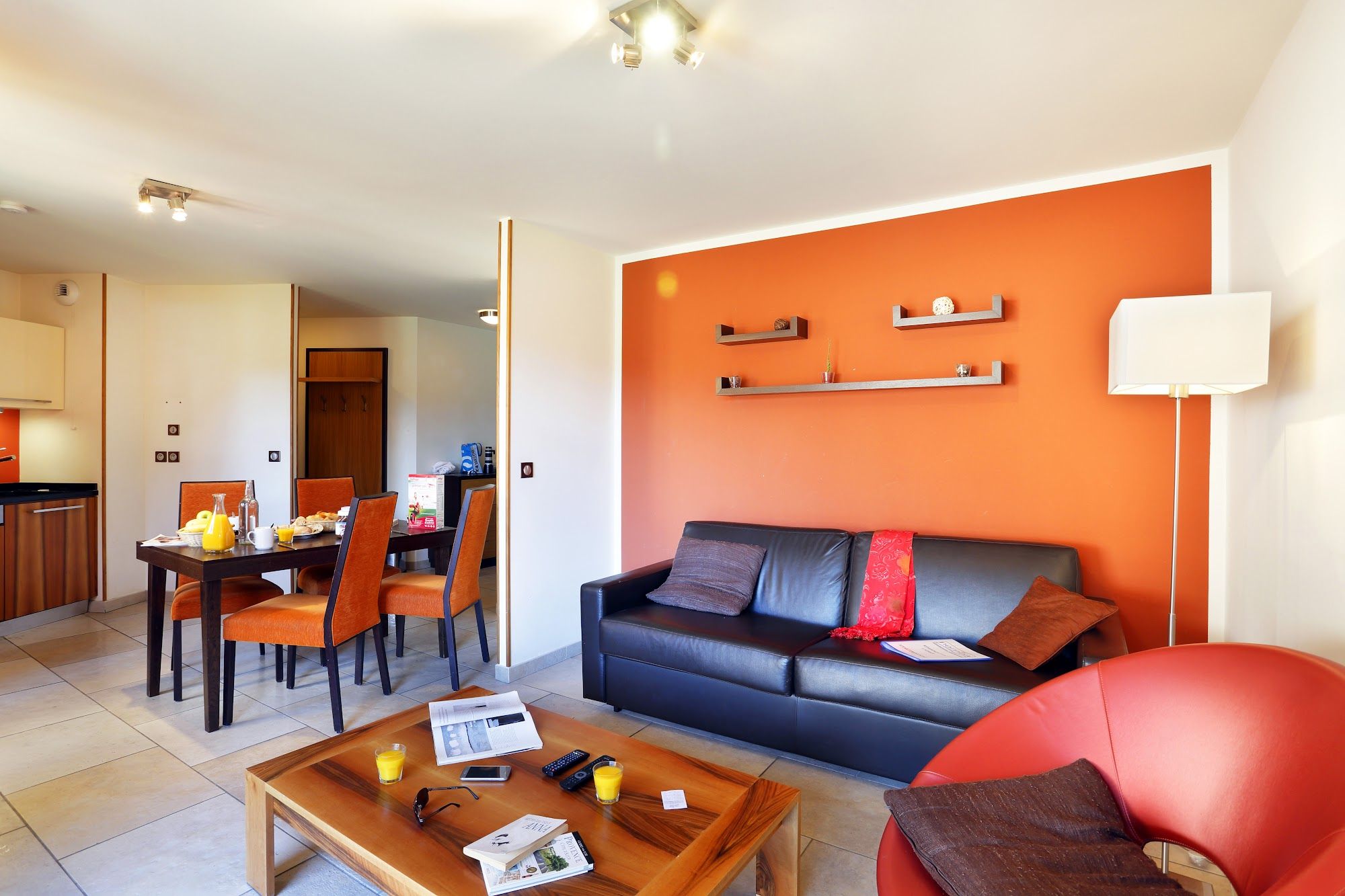 image A black leather sofa and warm accent wall make for easy evenings in.