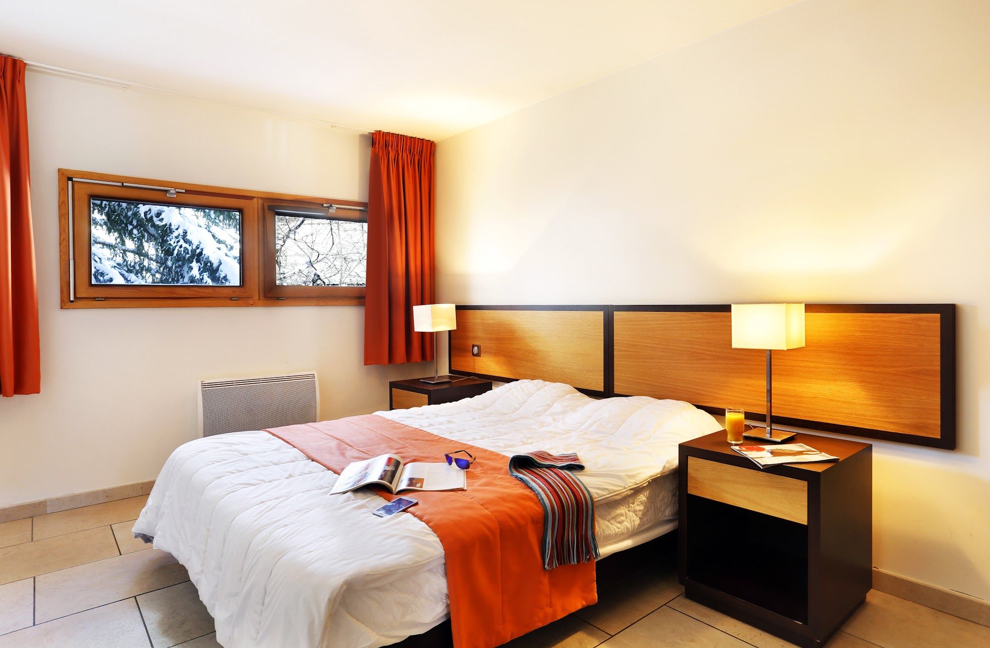 image Orange and white linens brighten the double bedroom.