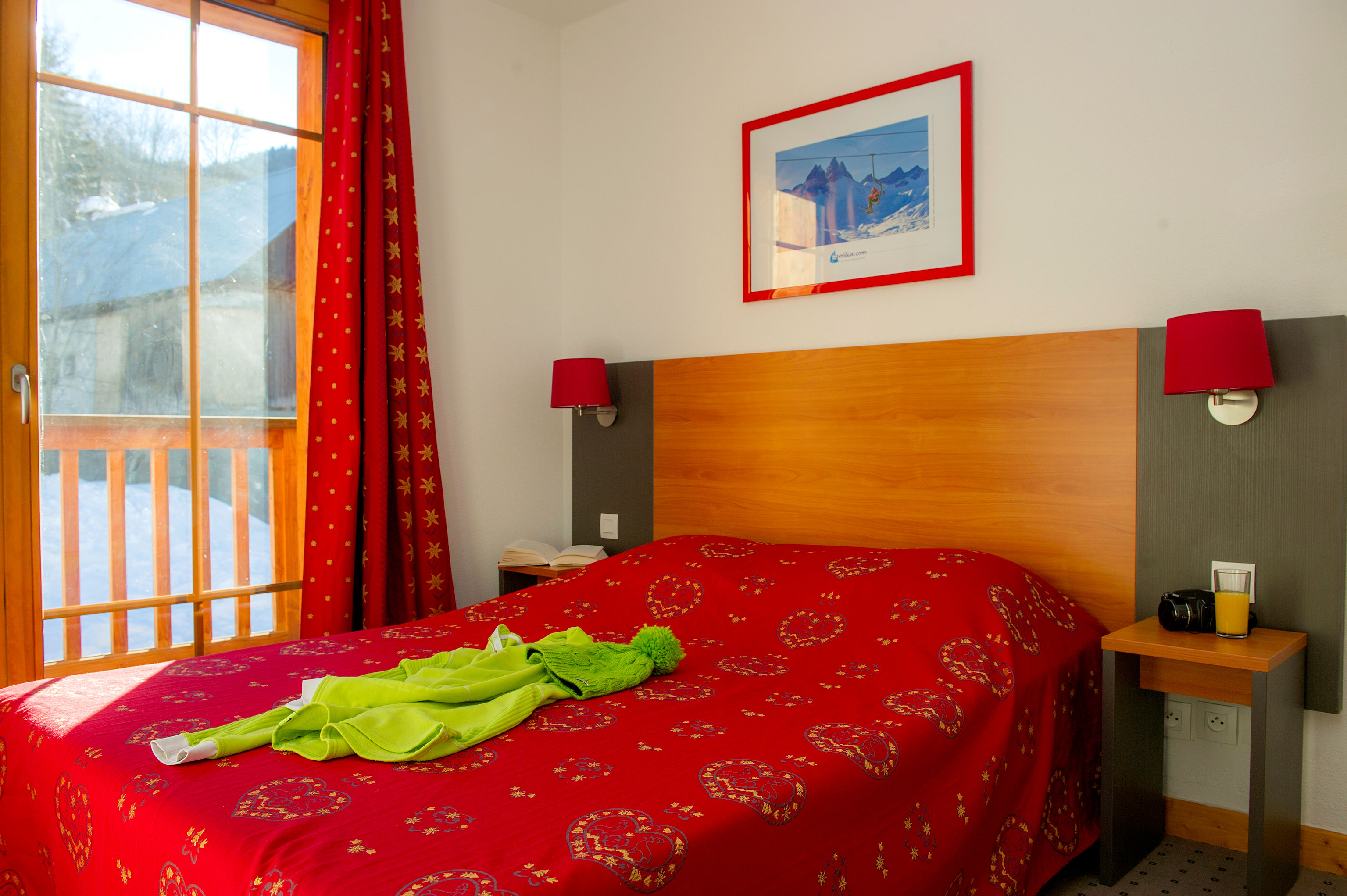 image Red tones and a wooden headboard warm up the double bedroom.