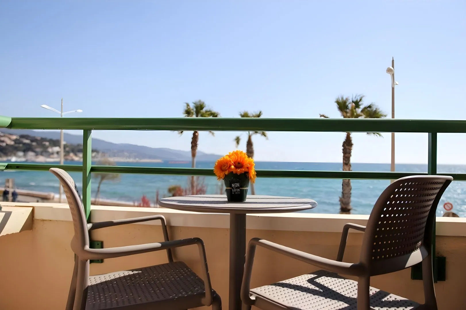 image Balcony with table and chairs overlooking the sea.