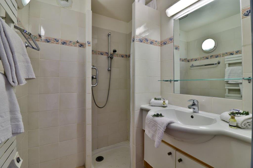 image Small bathroom with a shower, mirror, and sink.