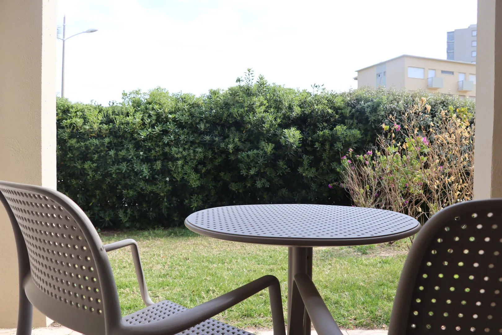 image Two chairs and round table on grassy patio.