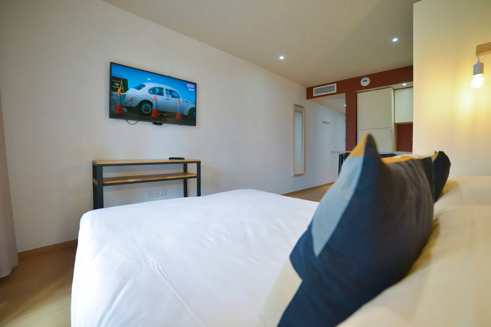image Studio with bed, TV, and wooden furniture.
