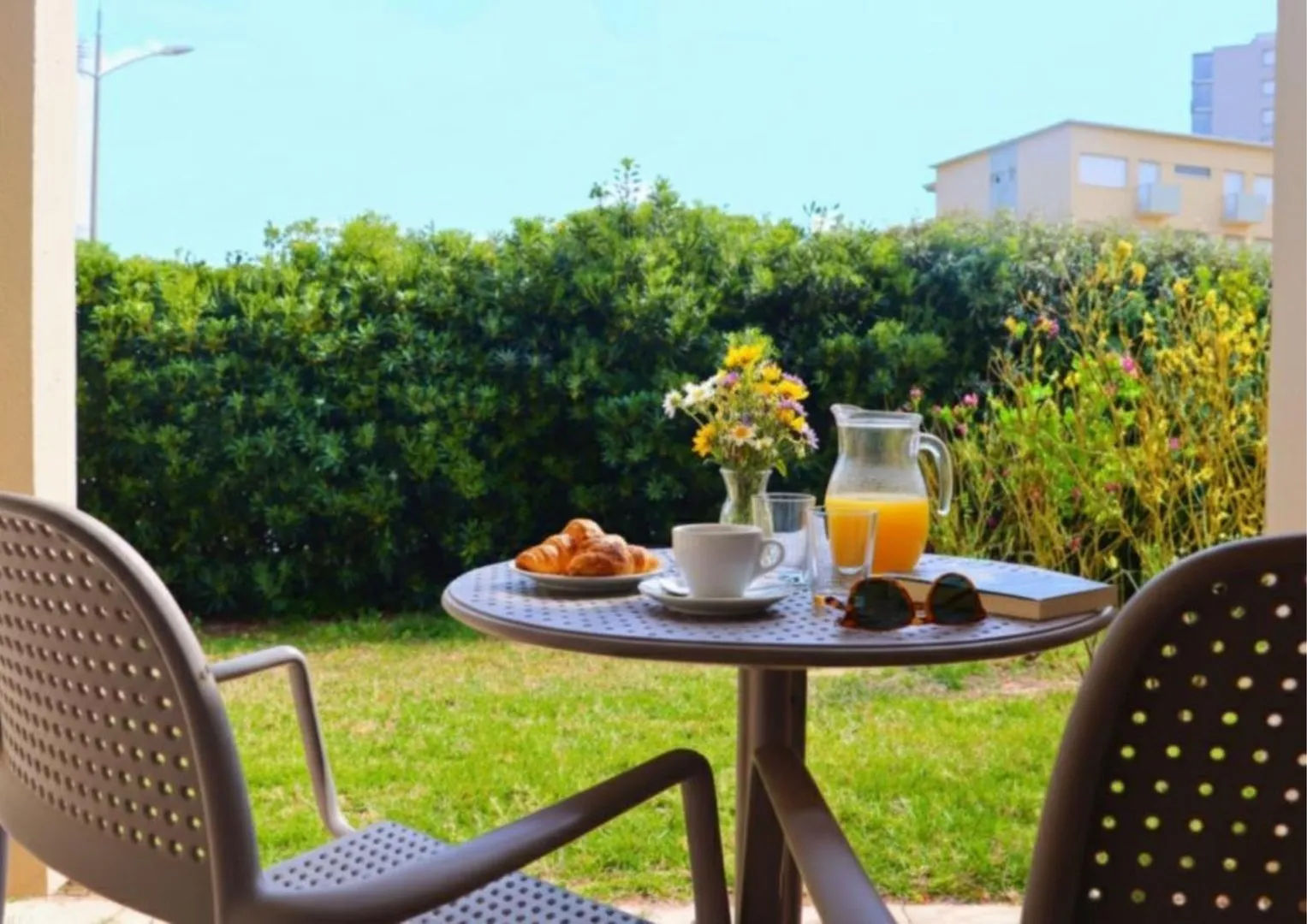 image Table setting with flowers and croissants on patio.