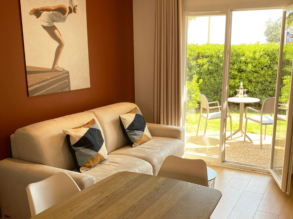 image Living area with a sofa, table, chairs, and sliding door.