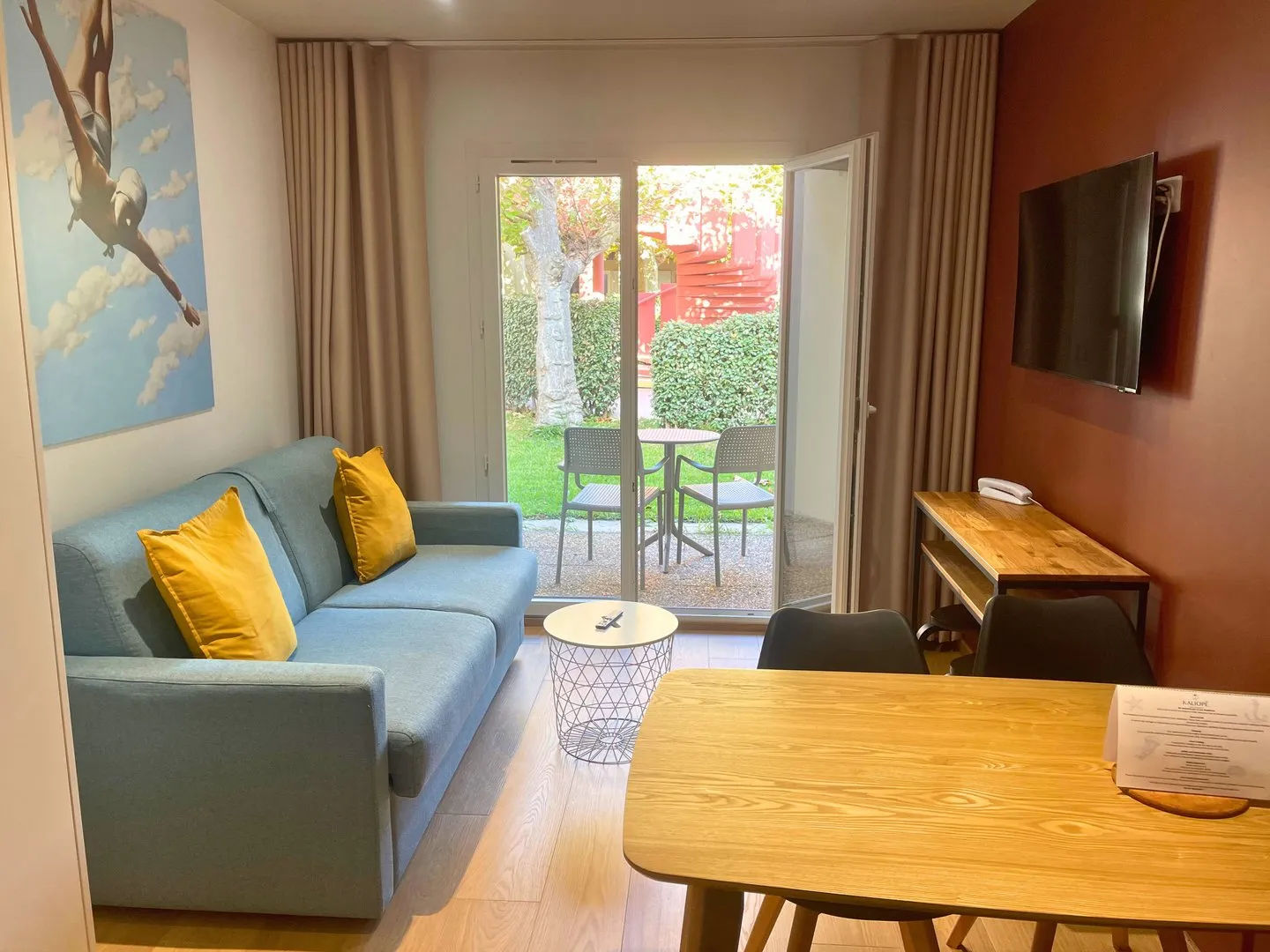 image Living room with blue couch, courtyard visible outside.