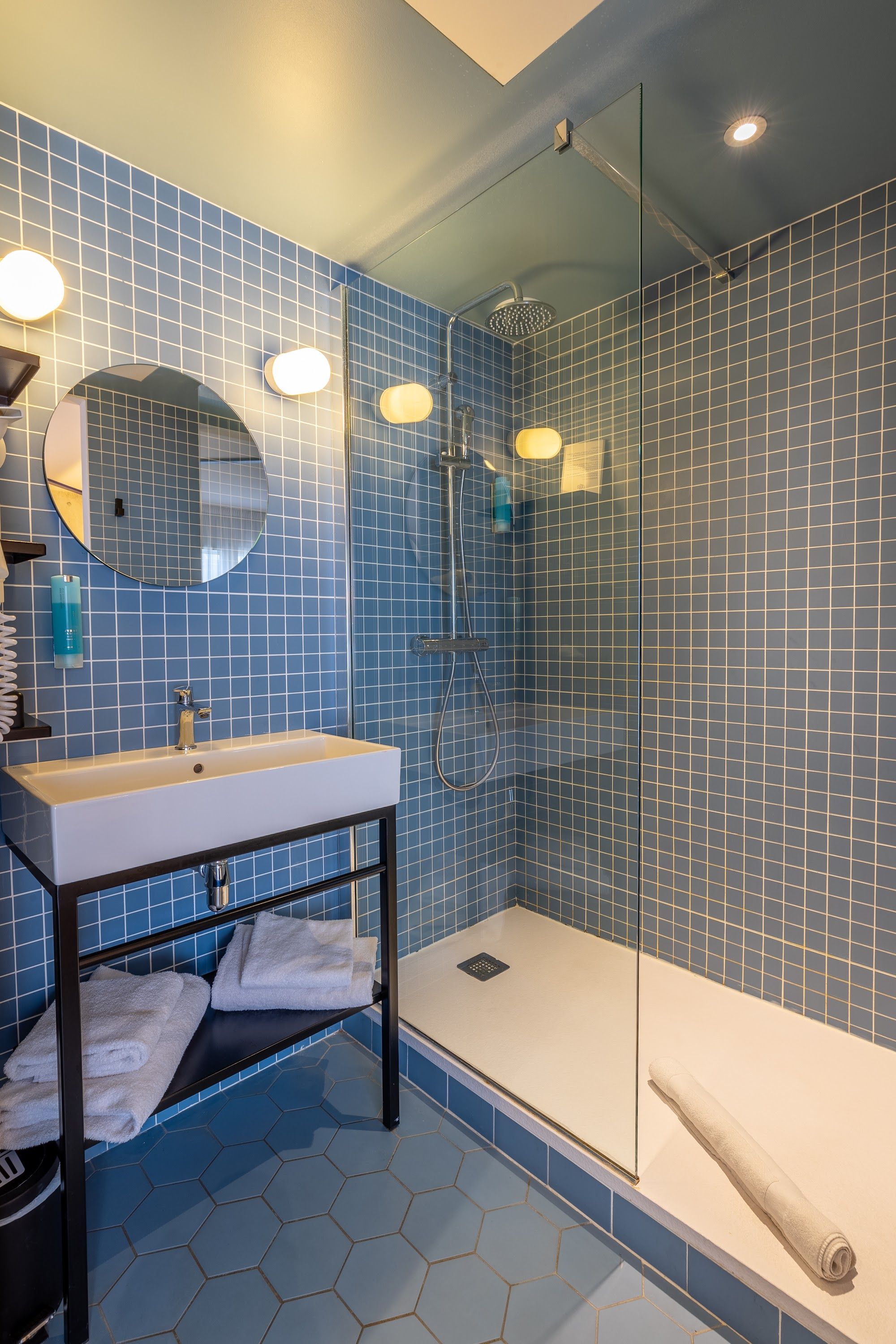 image Shower area with blue tiled walls and glass door