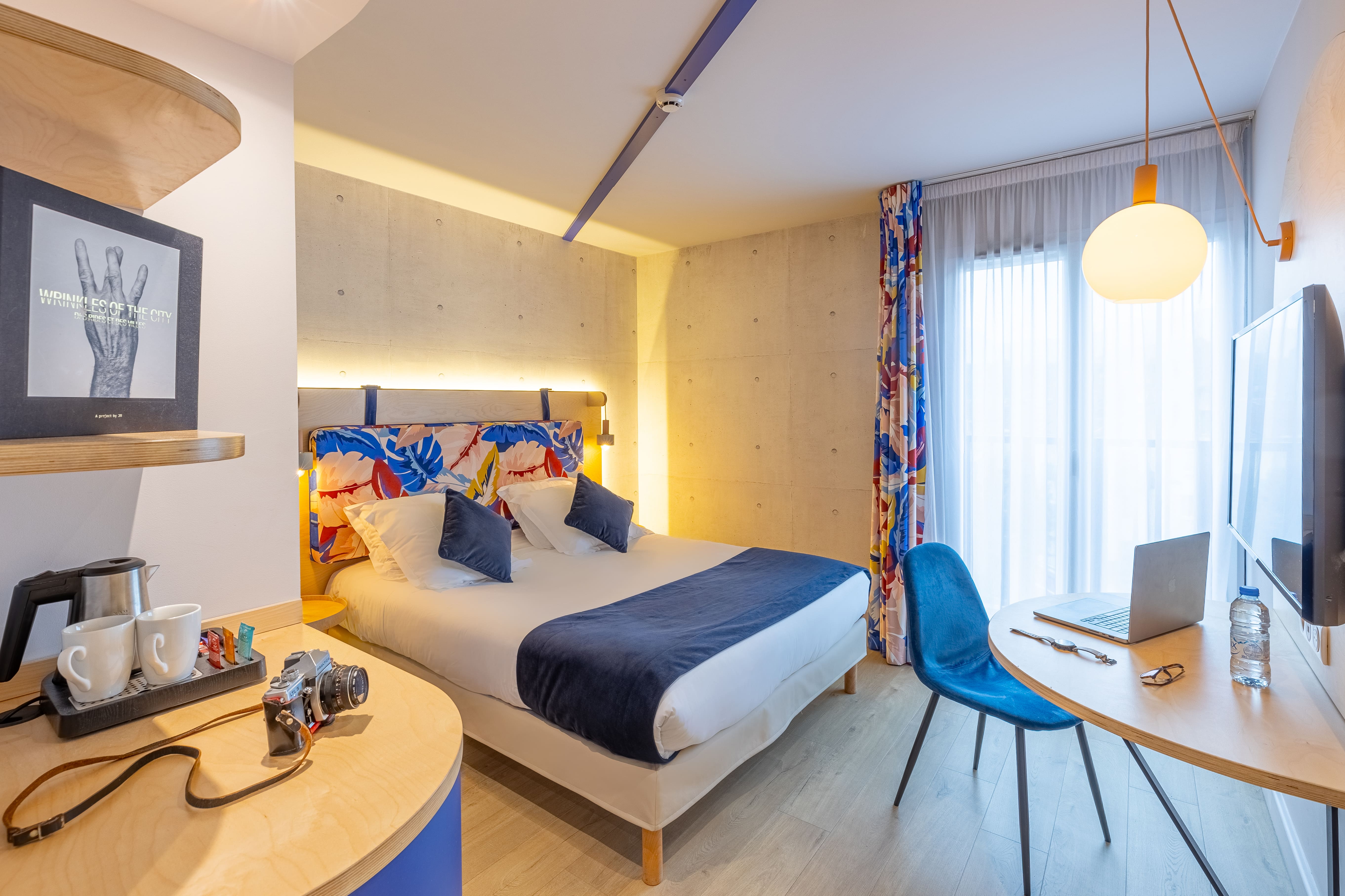 image Bold floral patterns brighten the headboard and curtains, with a private desk and chair for catching up on work