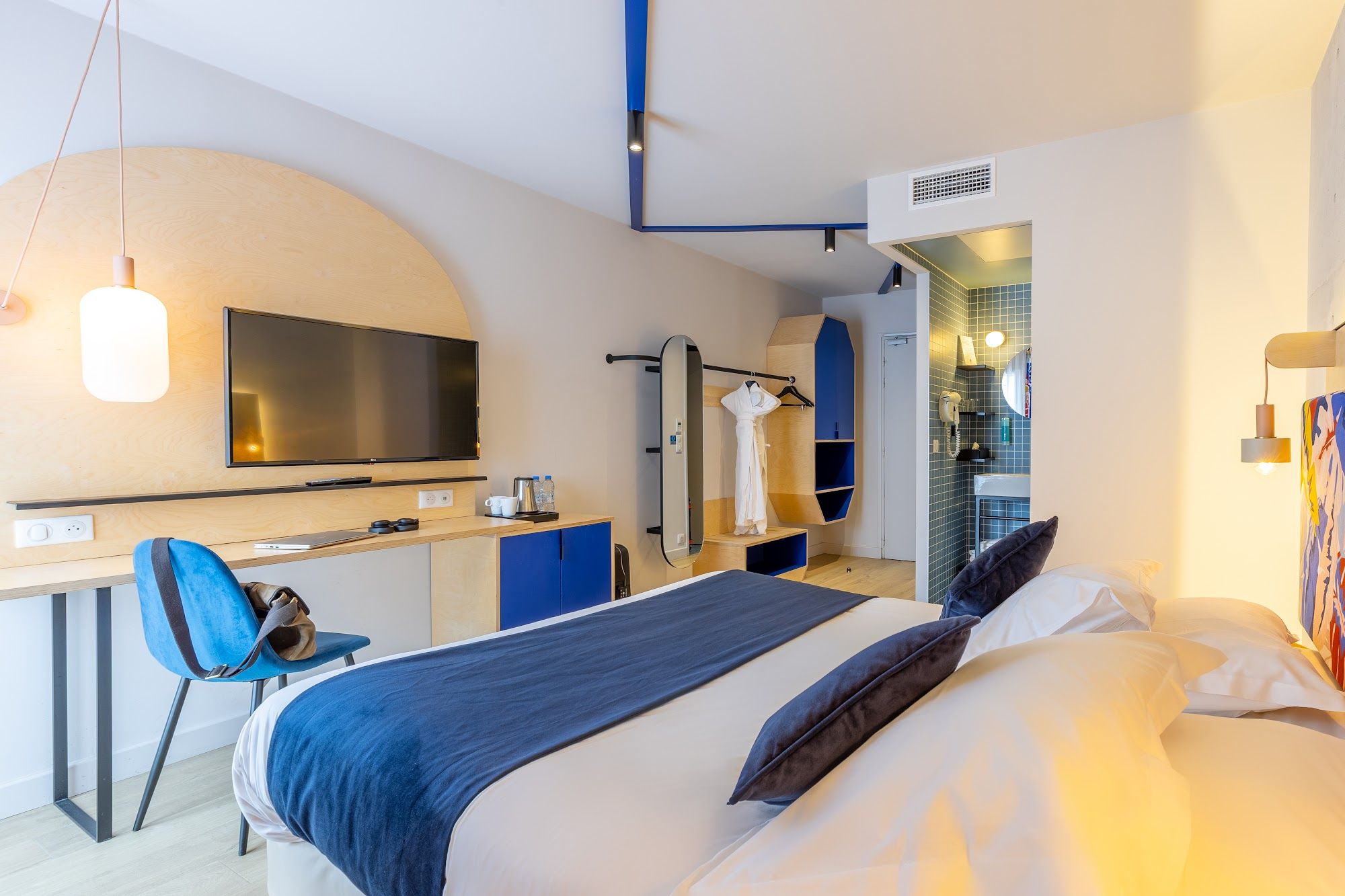 image Room with a TV, armchair, and open bathroom access