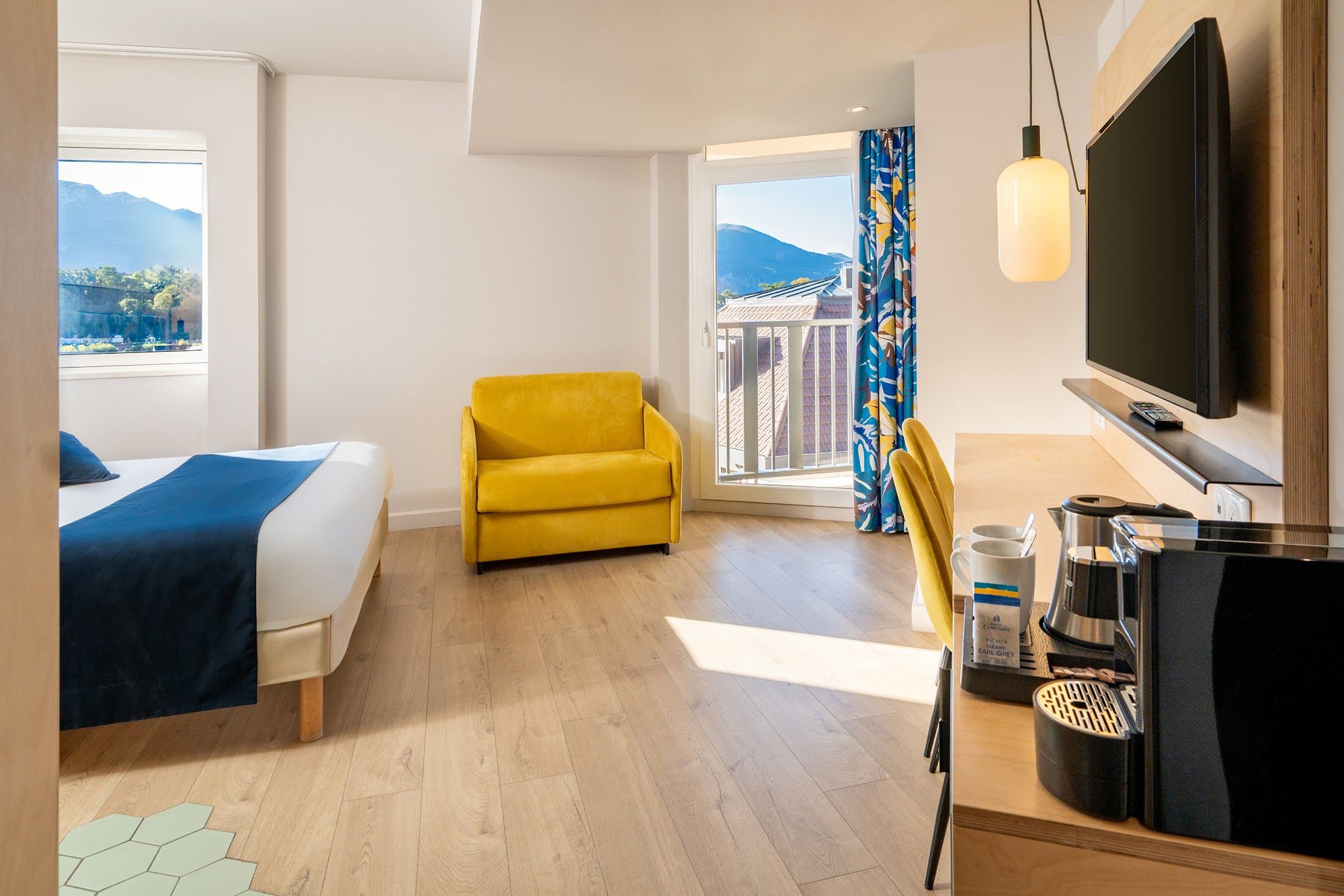 image Bright room with yellow chair, window, and kitchenette area
