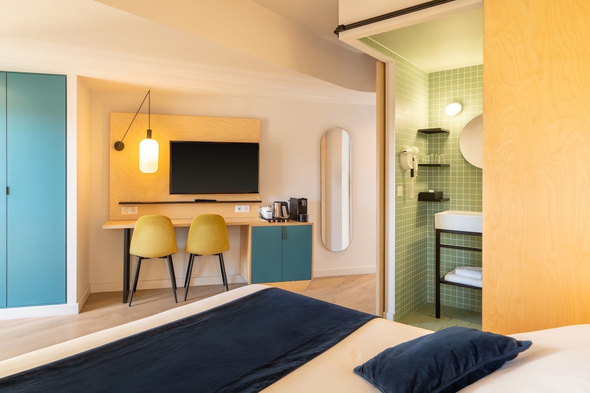 image Room with a TV desk and bathroom area with green tiles