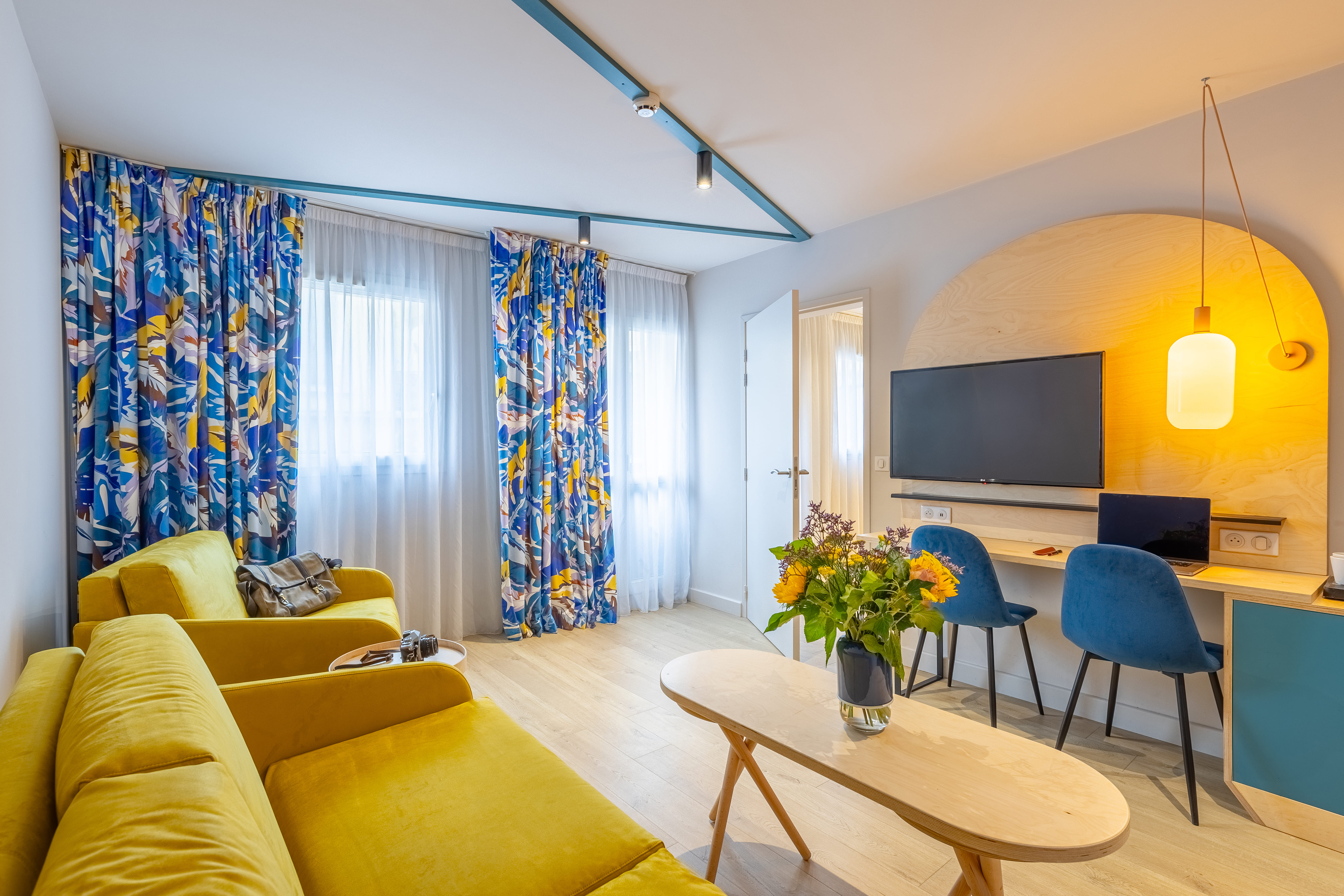 image The separate living room's mustard velvet sofa and wall-mounted TV create a lounge space apart from the bedroom
