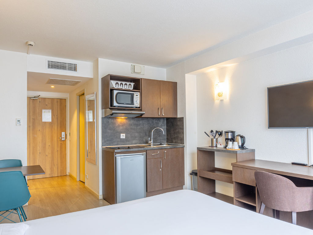 image Studio with kitchen area, table, chairs, and television