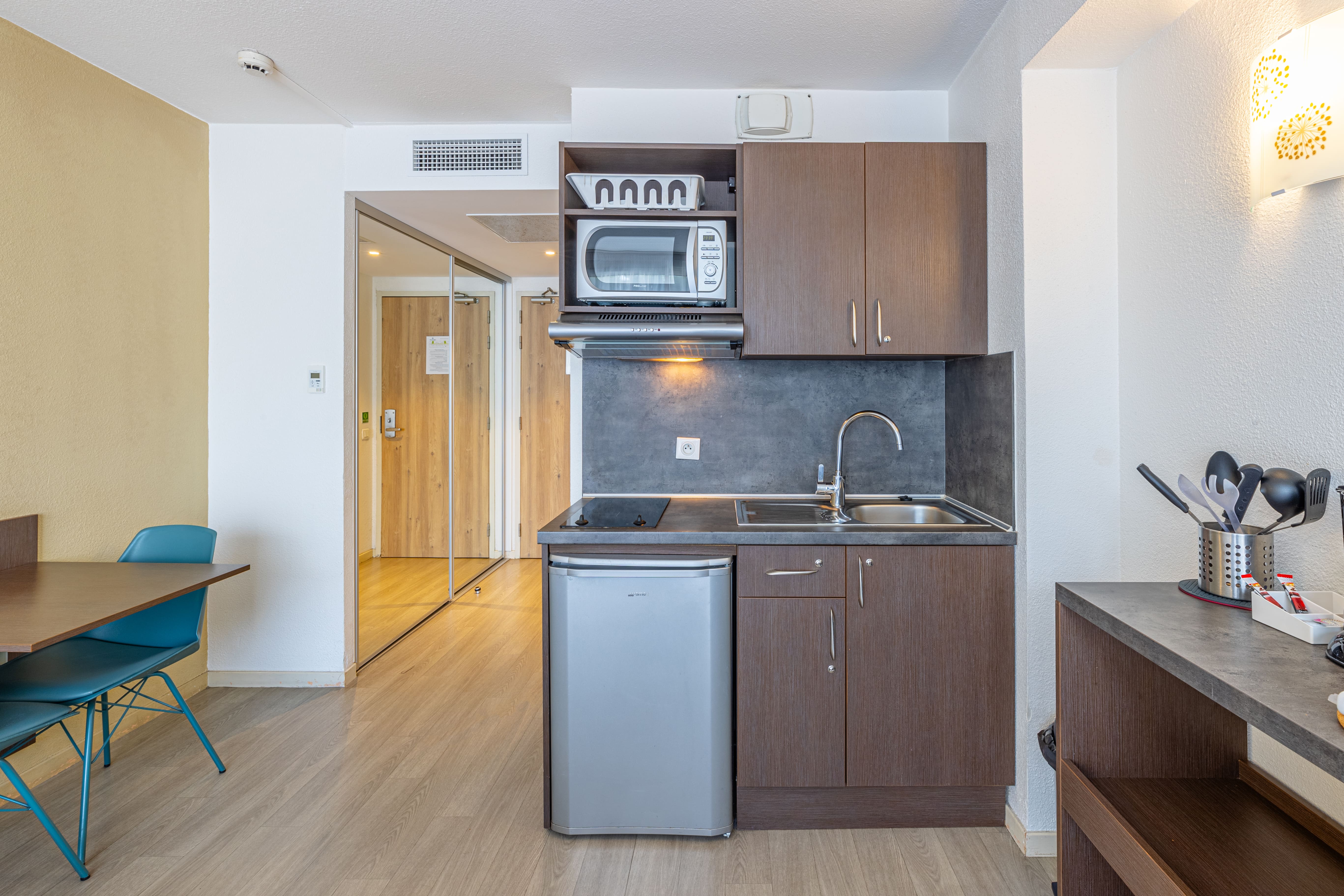 image Cozy kitchenette with appliances and dining area.
