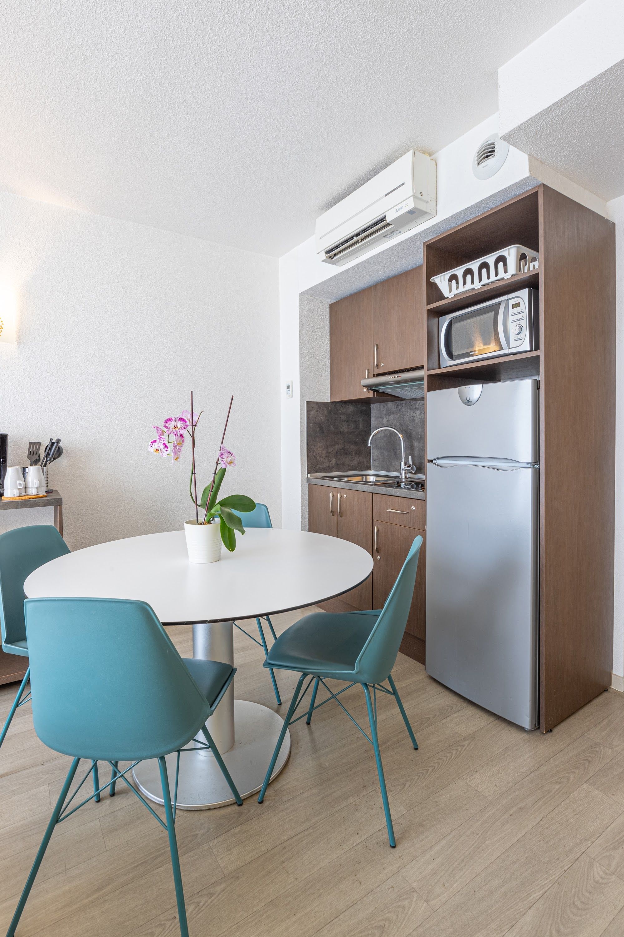 image Kitchen area with round table, chairs, and refrigerator