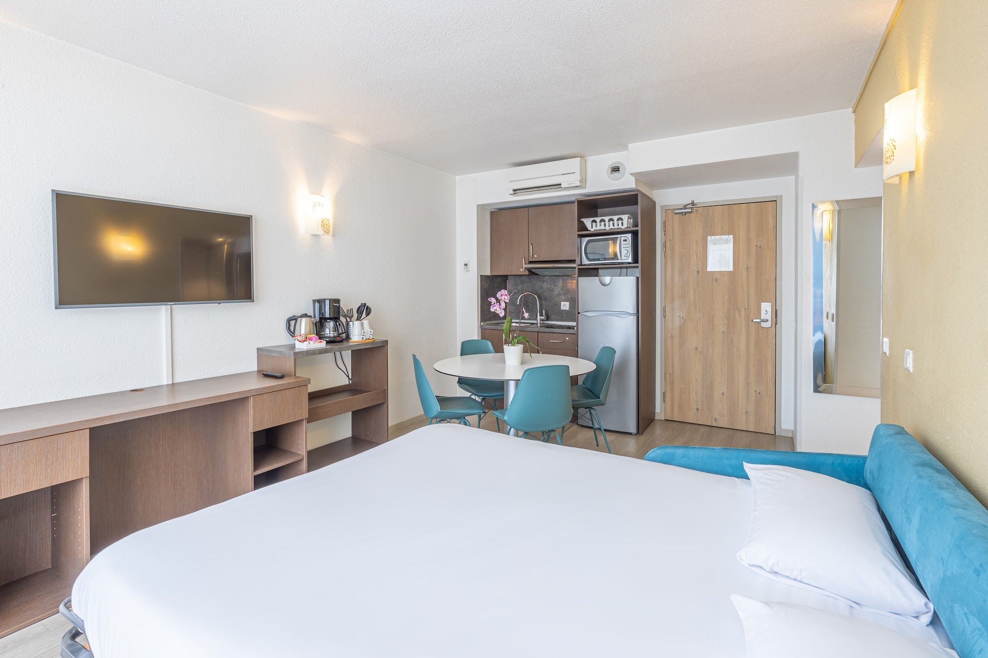 image Room with bed, TV, kitchen area, and dining table