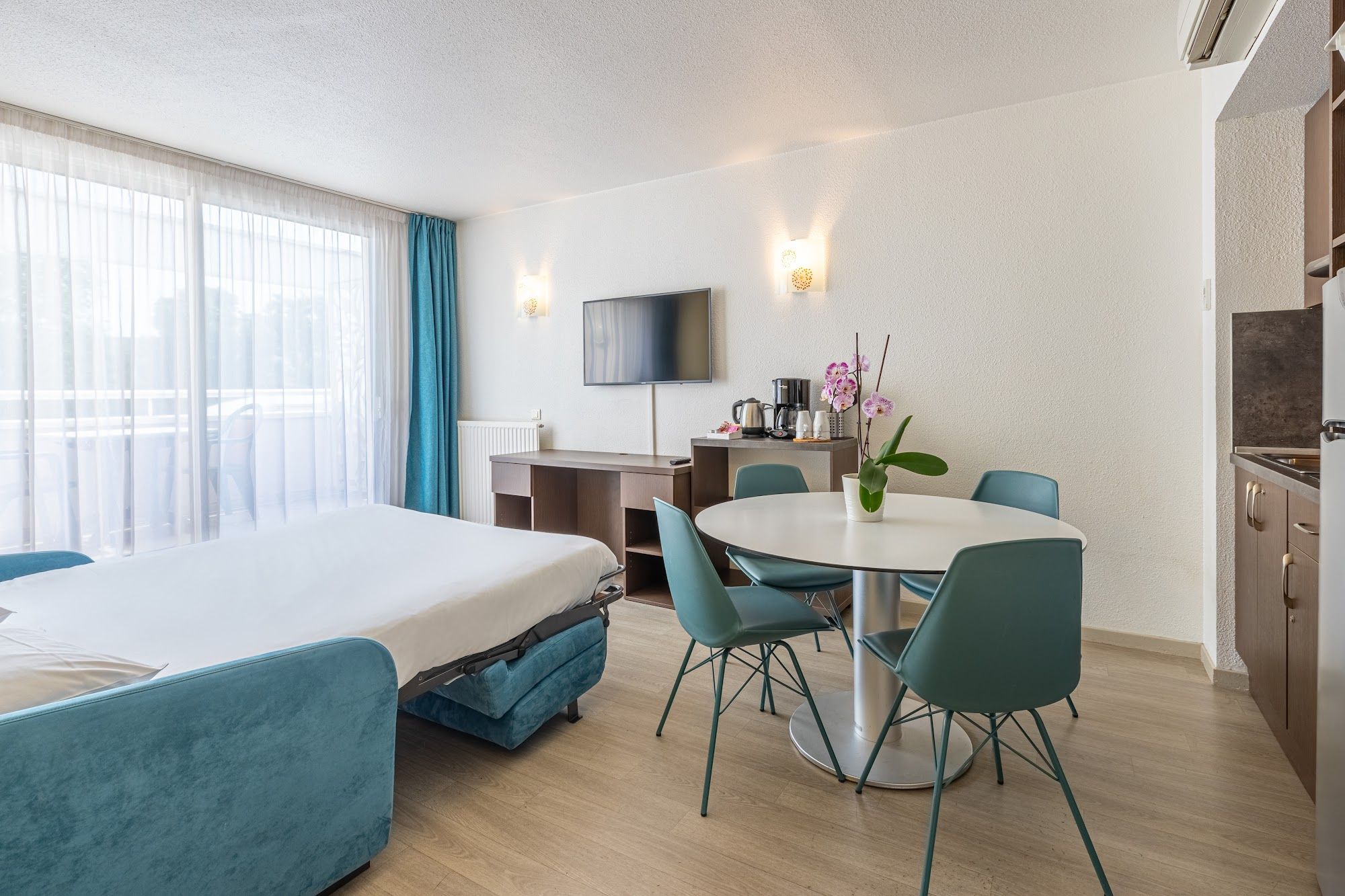 image Room with bed, dining table, TV, and kitchenette