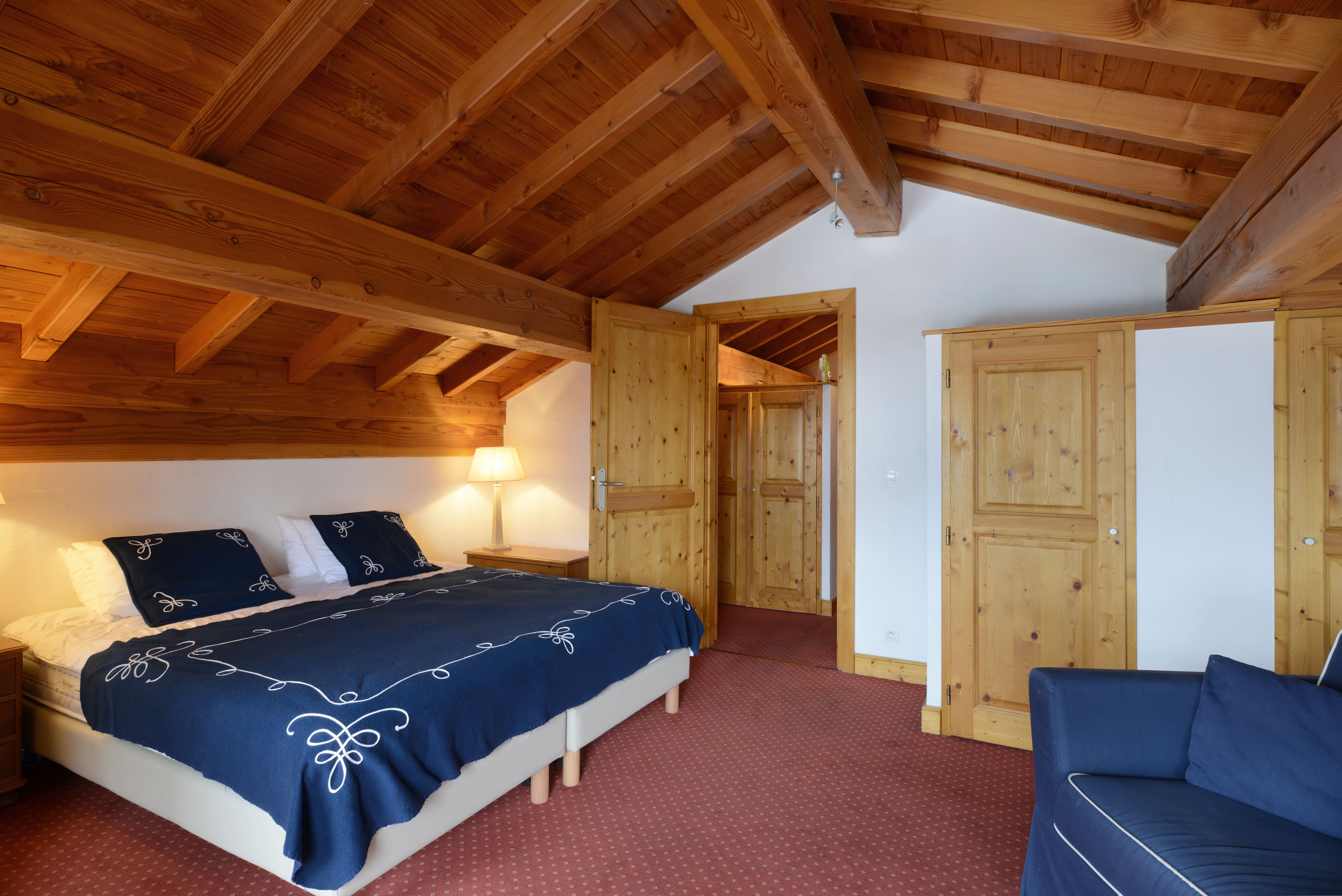 image Bedroom with vaulted wood-beamed ceilings, reached by a spiral staircase.