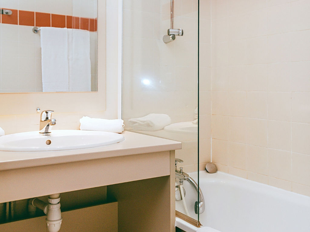 image Bathroom with sink, mirror, and bathtub/shower.