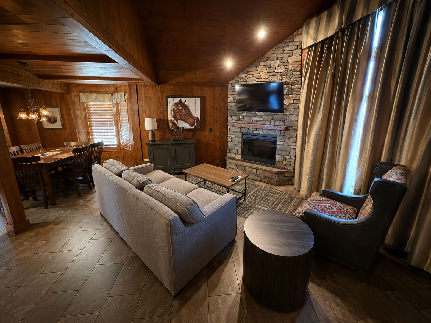 image Living area with wall-mounted TV and horse artwork on display.