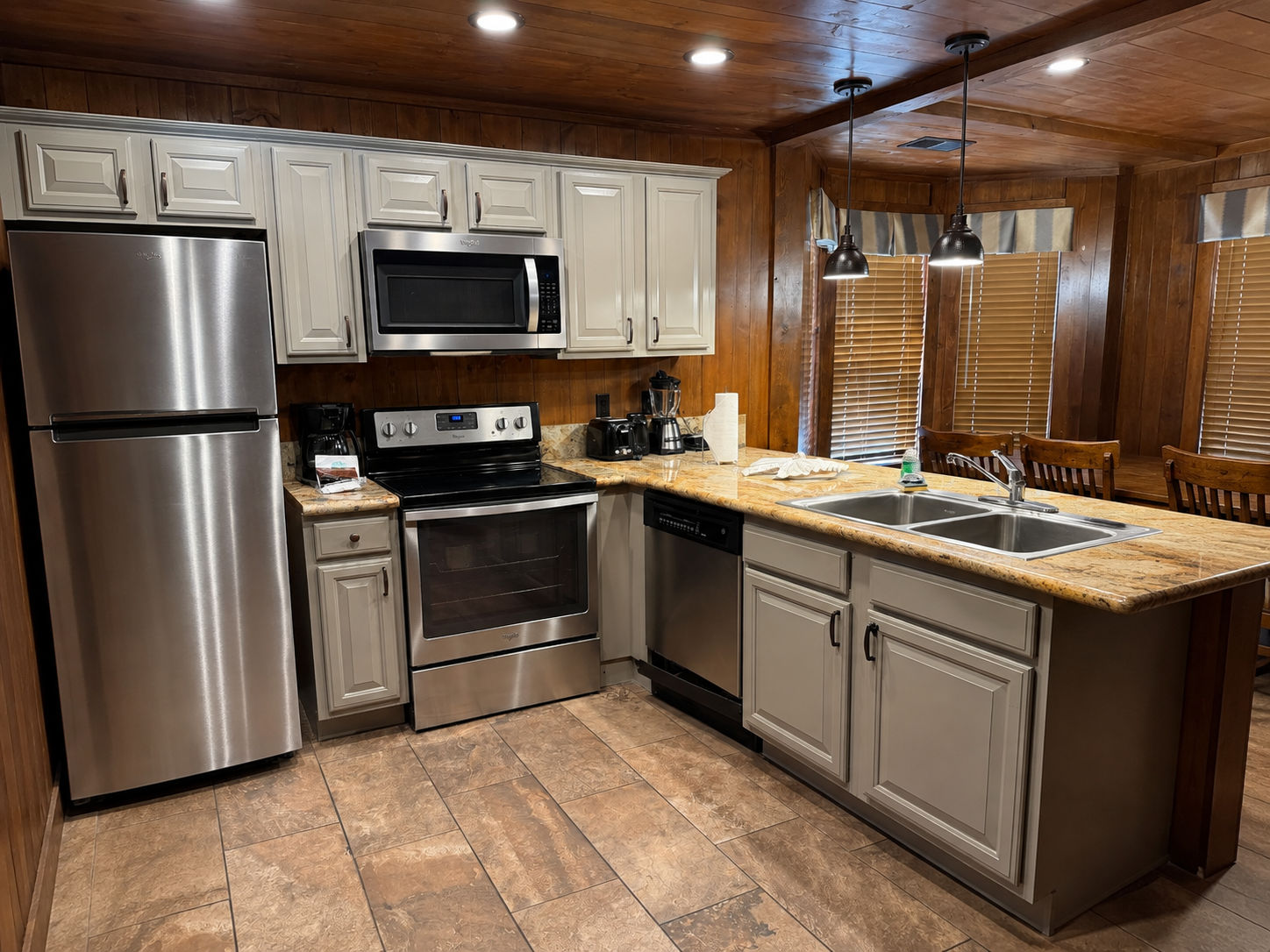 image Kitchen with stainless steel appliances, granite countertops, and overhead lighting.