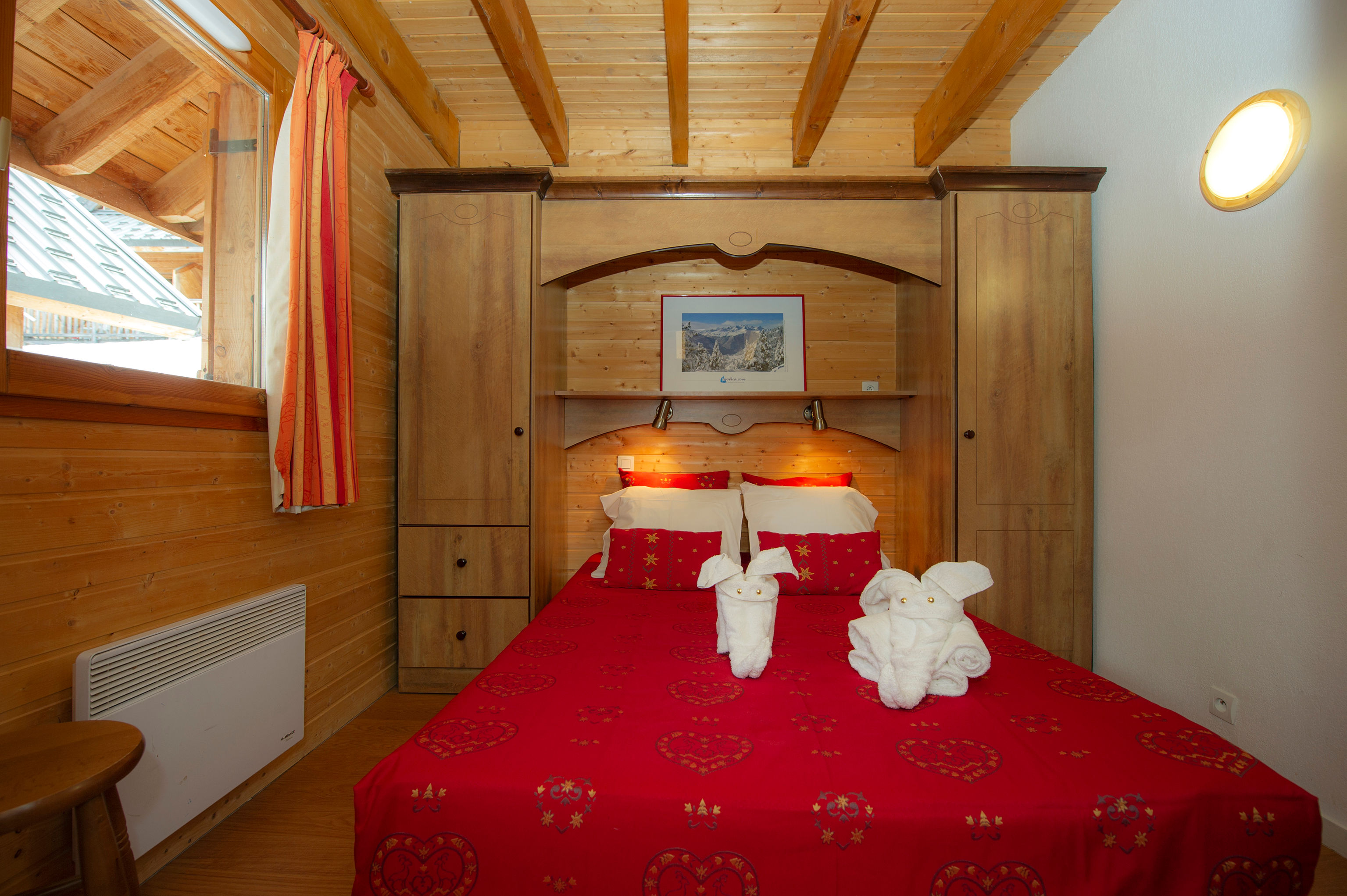 image Towel swans sit folded on the ground-floor double bed, tucked between built-in wardrobes and bedside lamps.