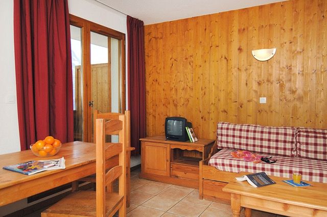 image Compact living space with wood panelling and a glass door onto the balcony.