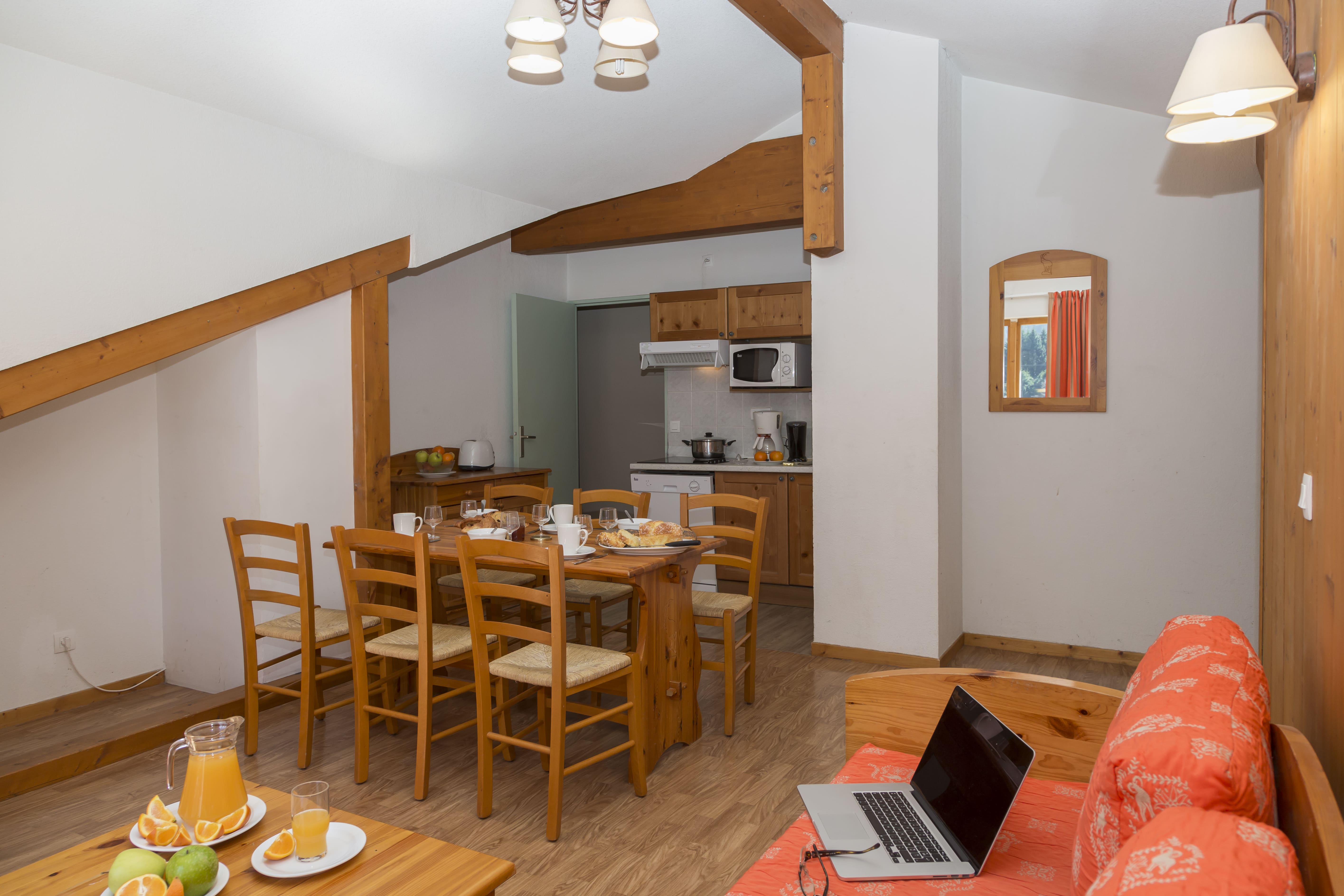image The open-plan living and dining area, with kitchenette and TV.