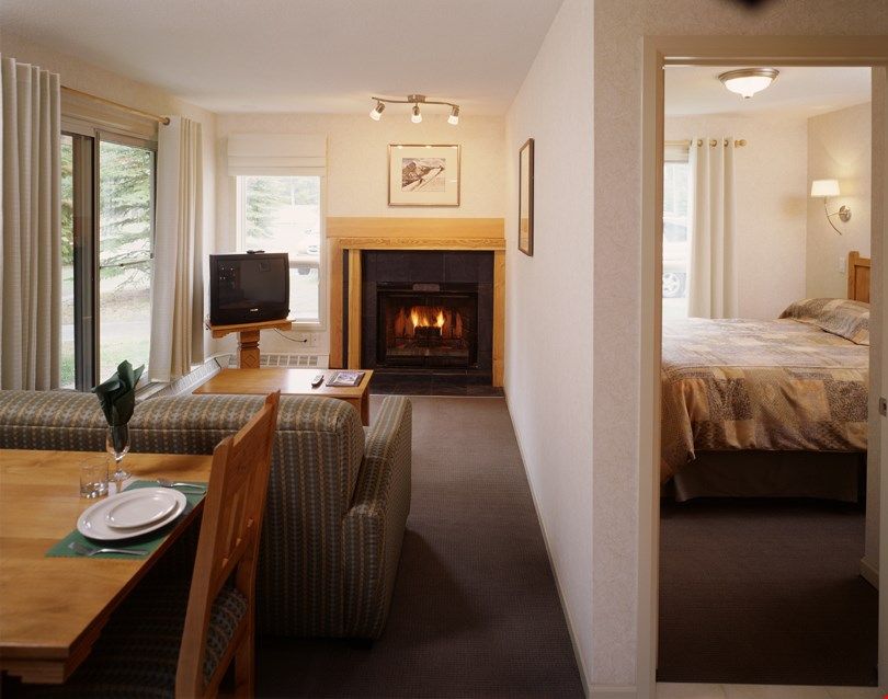 image Relax in the charming open-concept living space while you warm up by the fireplace.