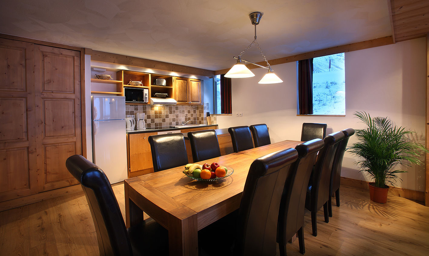 image Large wooden dining table with leather chairs, next to the kitchen.